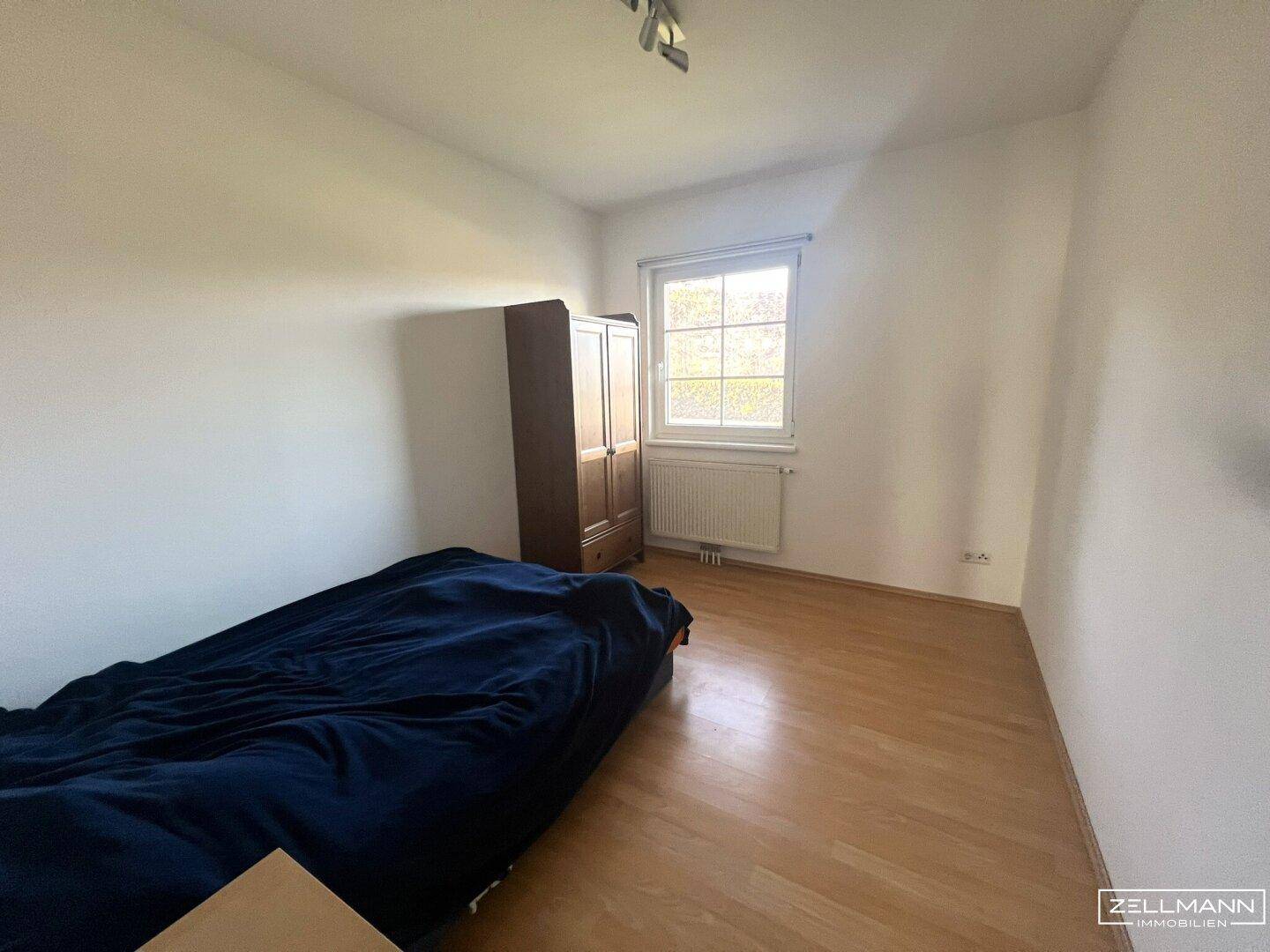 Schlafzimmer mit Holzboden und Fenster, bietet eine ruhige und gemütliche Atmosphäre.