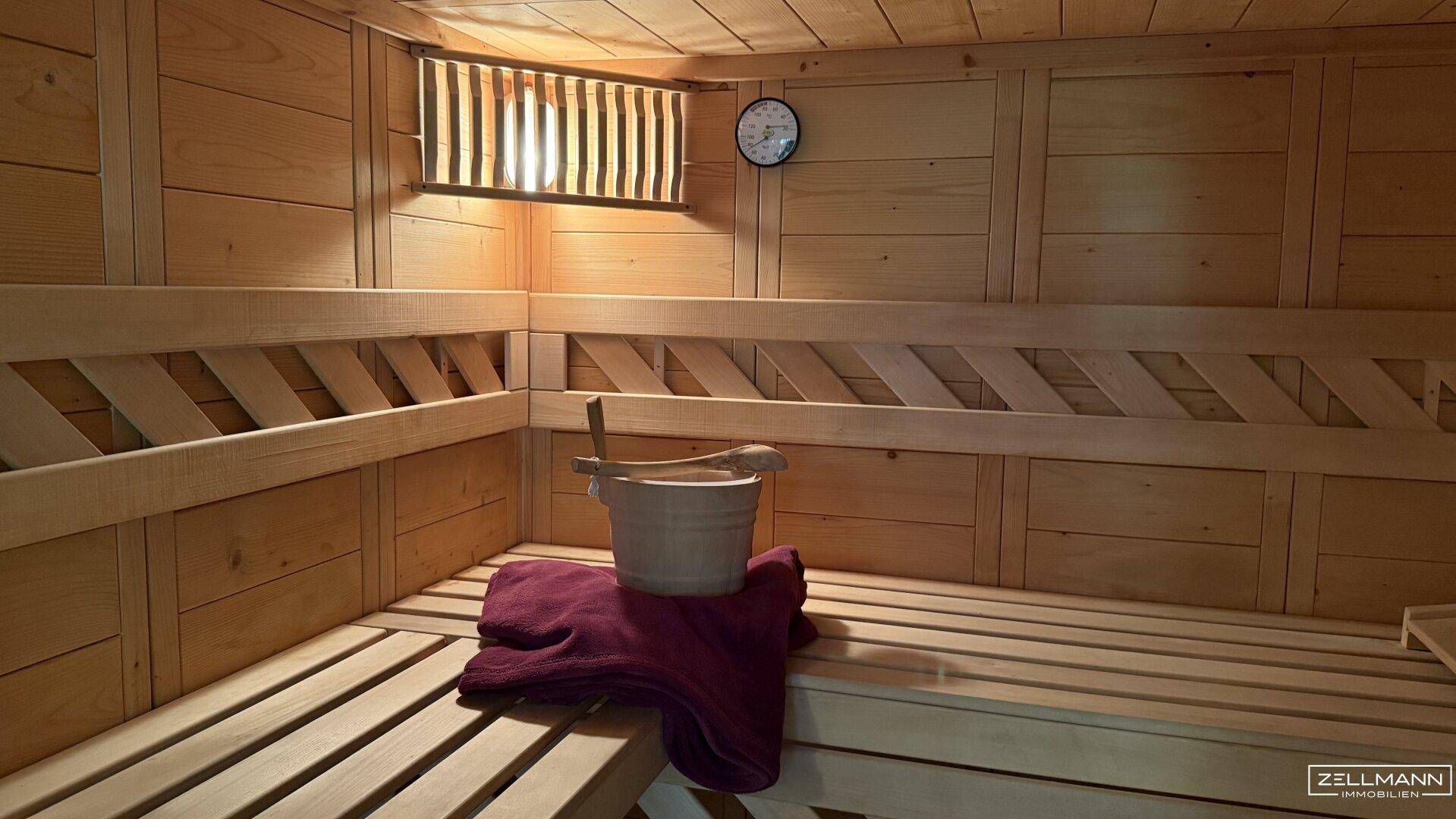 Traditionelle Holzsauna mit Bänken und klassischem Saunaeimer für Entspannung.