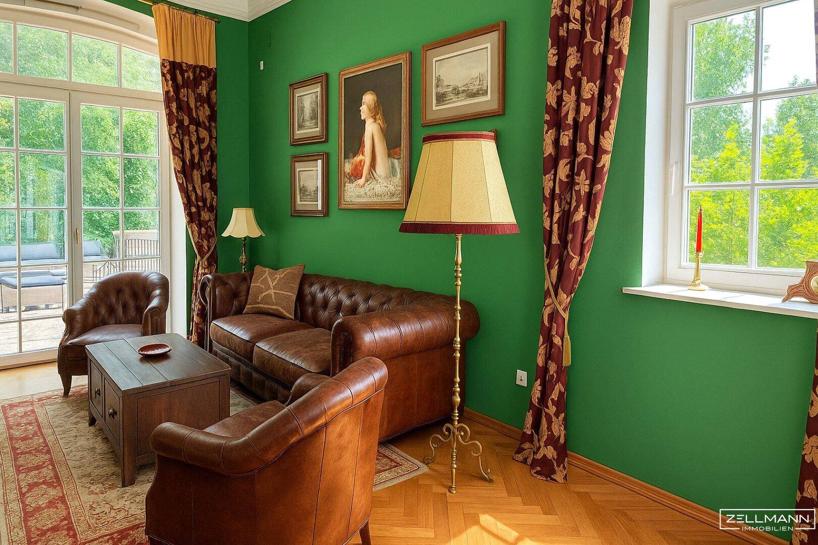 Gemütliches Wohnzimmer mit grünen Wänden, Chesterfield-Sofa und Zugang zum Balkon.
