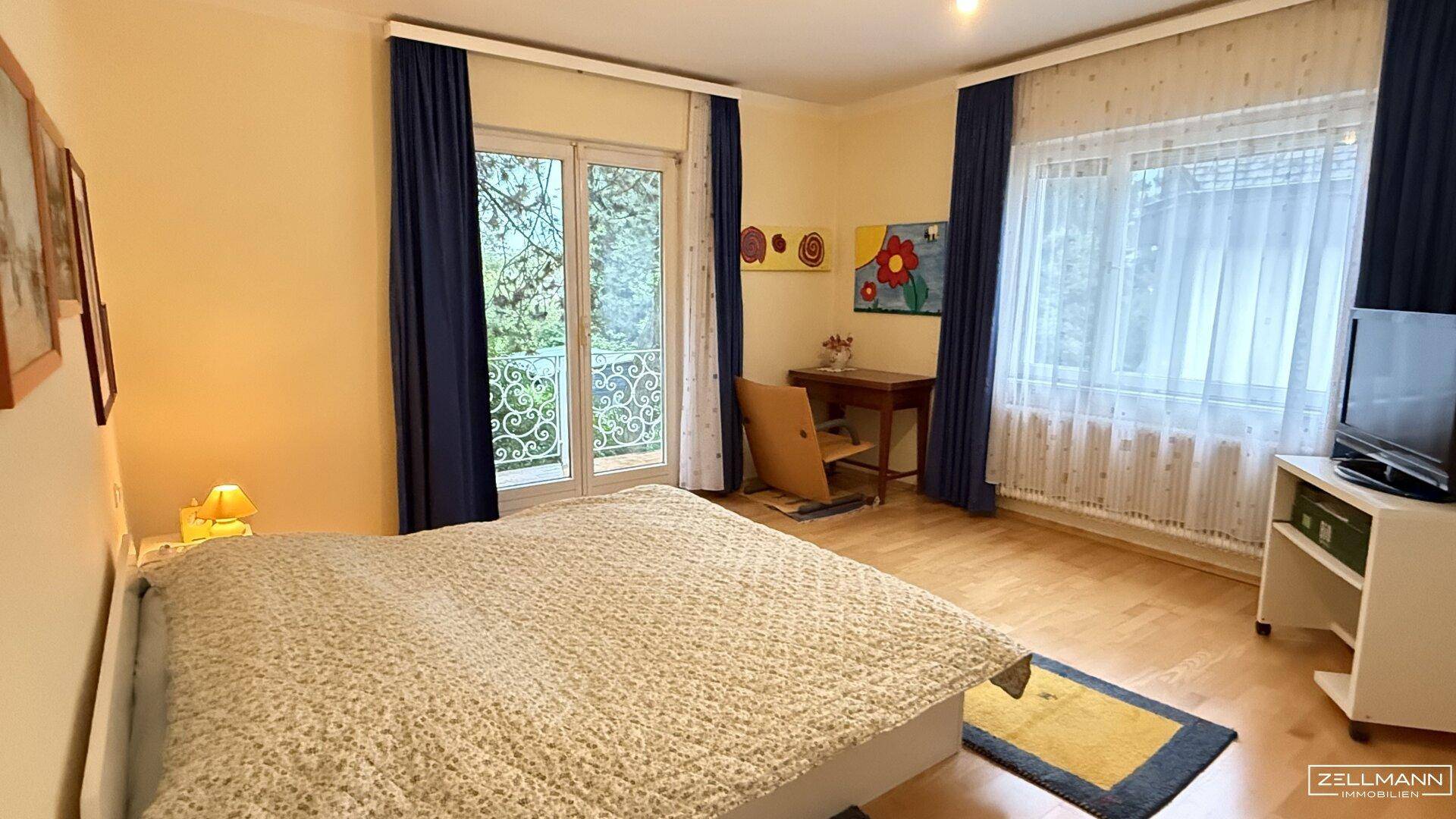 Gemütliches Schlafzimmer mit großem Bett, französischem Balkon und viel natürlichem Licht.