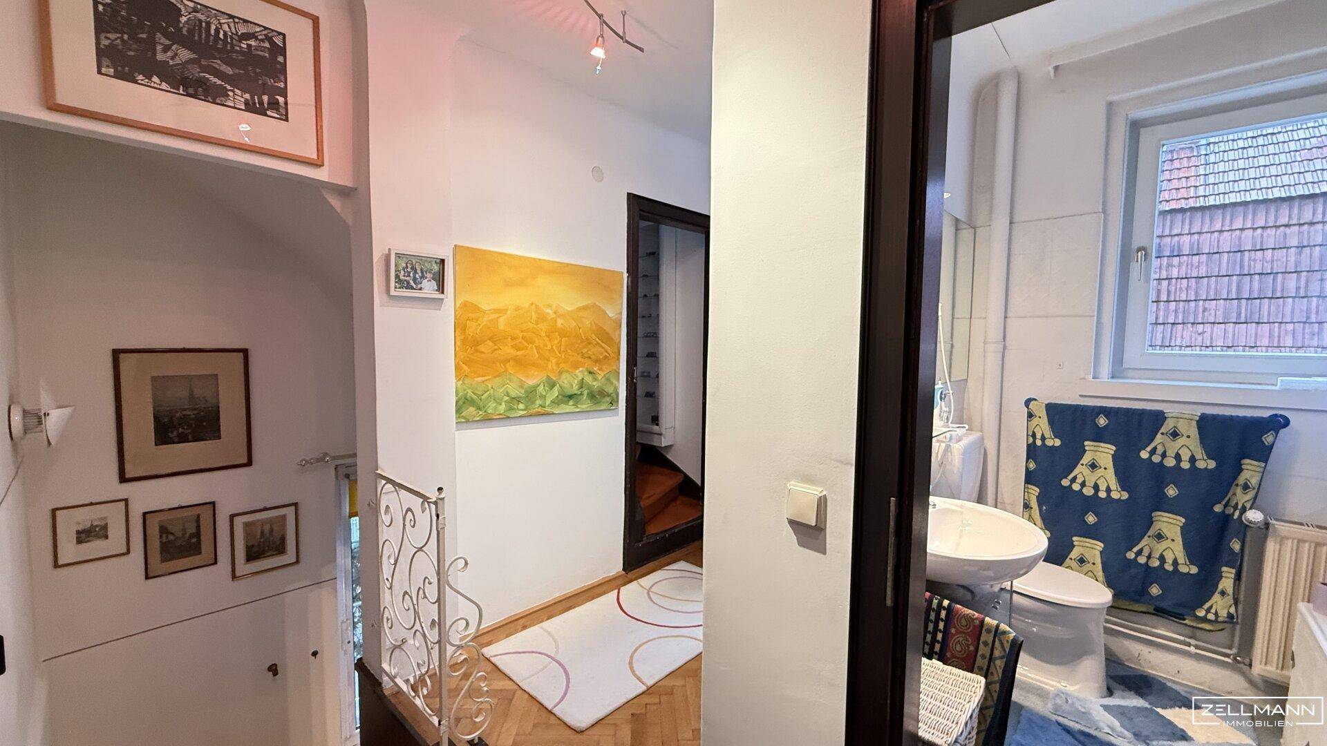 Innenraum mit Flur und Badezimmer, das ein Fenster und eine Toilette zeigt.