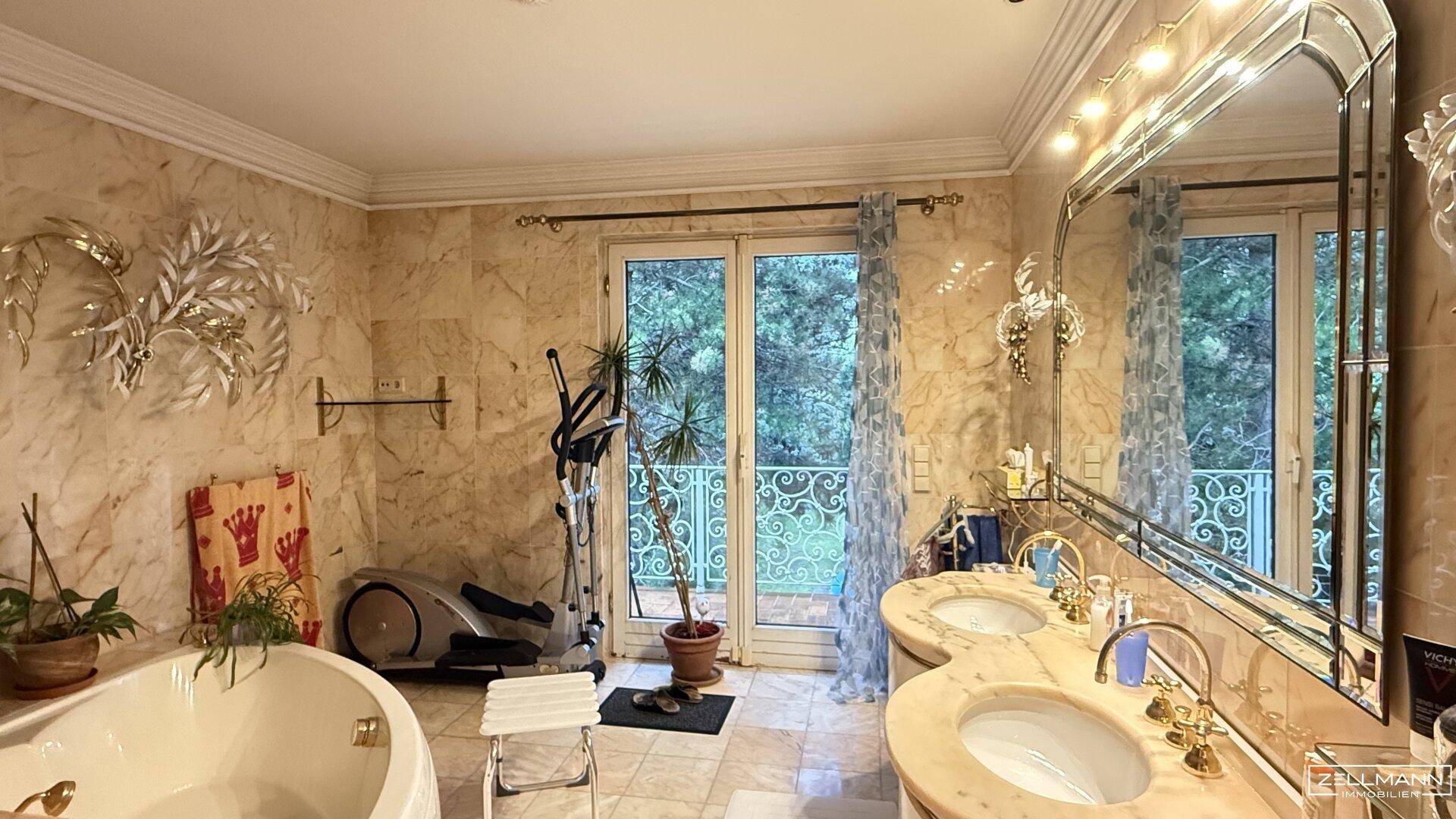 Luxuriöses Badezimmer mit Marmorfliesen, Doppelwaschbecken, Badewanne und französischem Balkon.