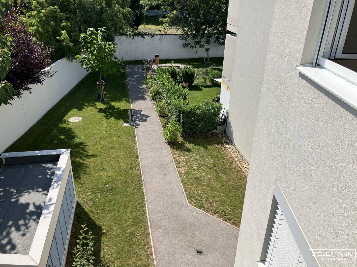 Gepflegte Gemeinschaftsgartenanlage mit Rasenflächen, Wegen und Hecken.