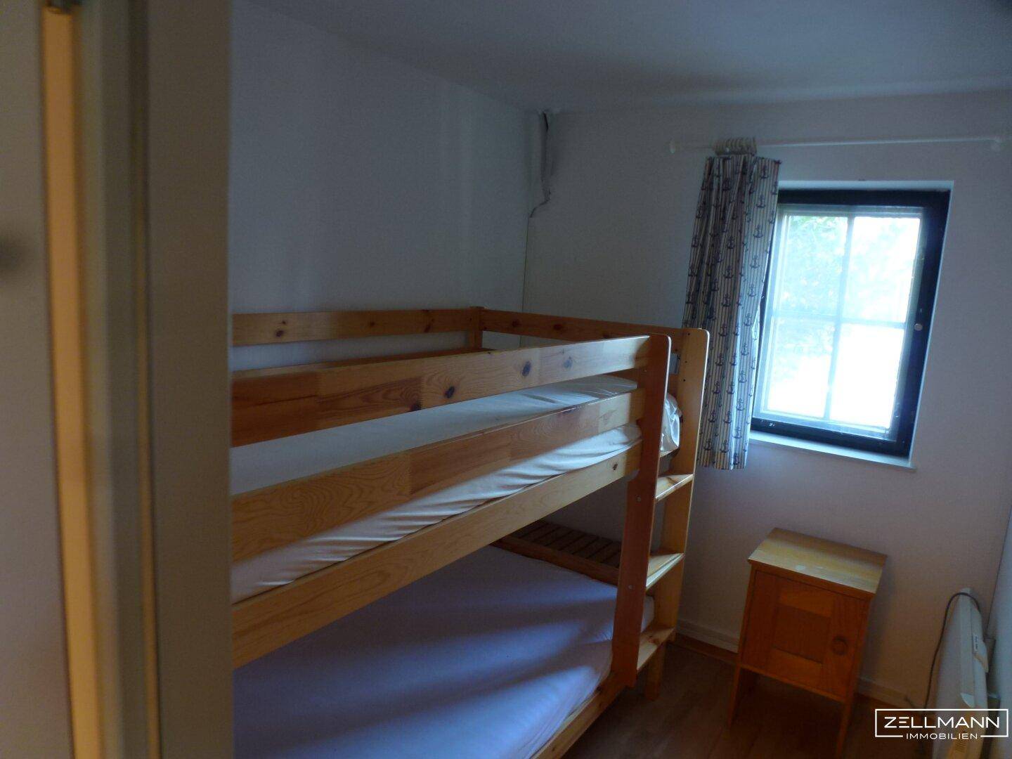Kinderzimmer mit Etagenbett und kleinem Fenster, ideal für Gäste oder Kinder.