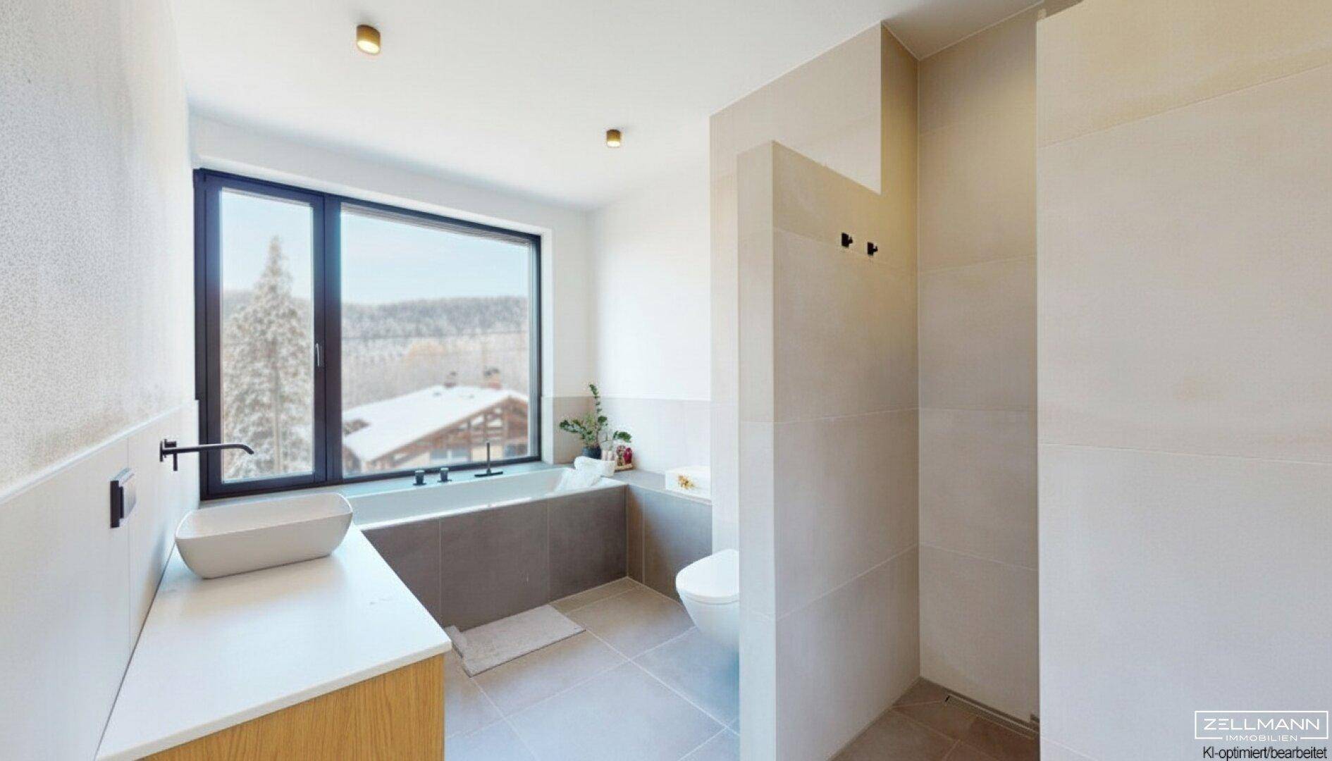 Modernes Badezimmer mit Badewanne, großem Fenster und Blick auf die winterliche Umgebung.