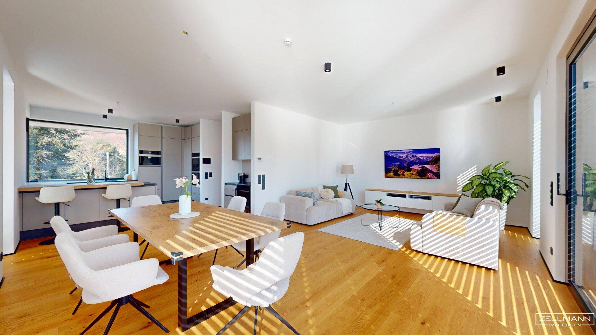 Geräumiger offener Wohn-Ess-Küchenbereich mit Holzboden und großen Fenstern für viel Licht.