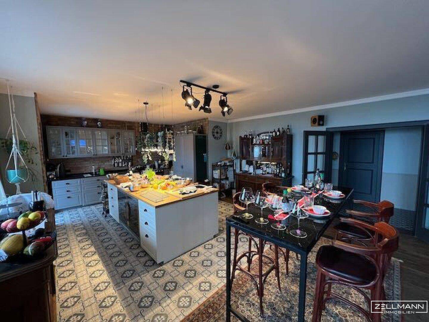 Geräumiger offener Wohn-Essbereich mit großer Kücheninsel und rustikalen Möbeln.