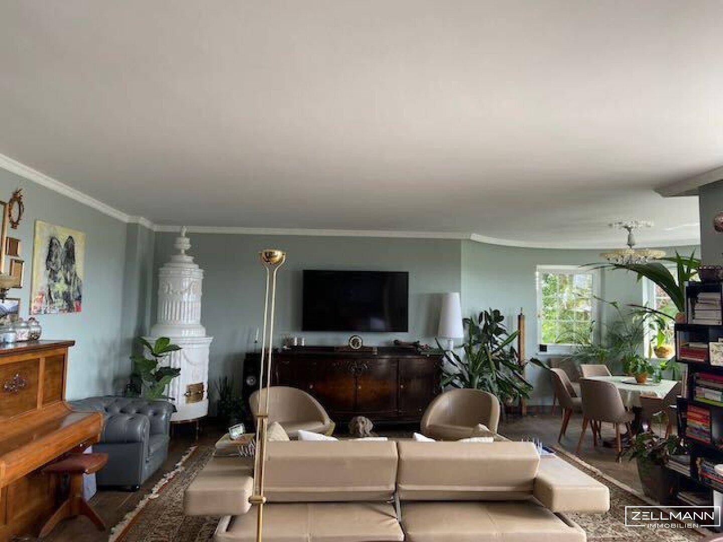 Geräumiger Wohnbereich mit Kachelofen, bequemen Sofas und Blick ins Grüne.