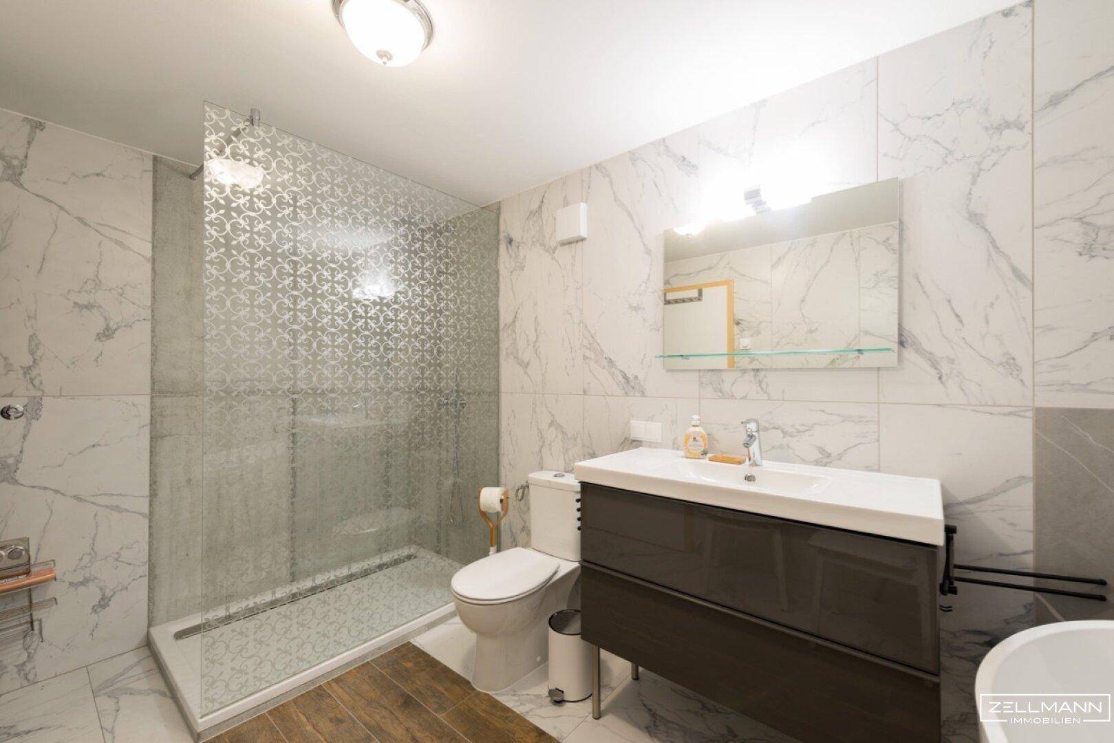 Modernes Badezimmer mit begehbarer Dusche, Marmorfliesen und Einzelwaschbecken.