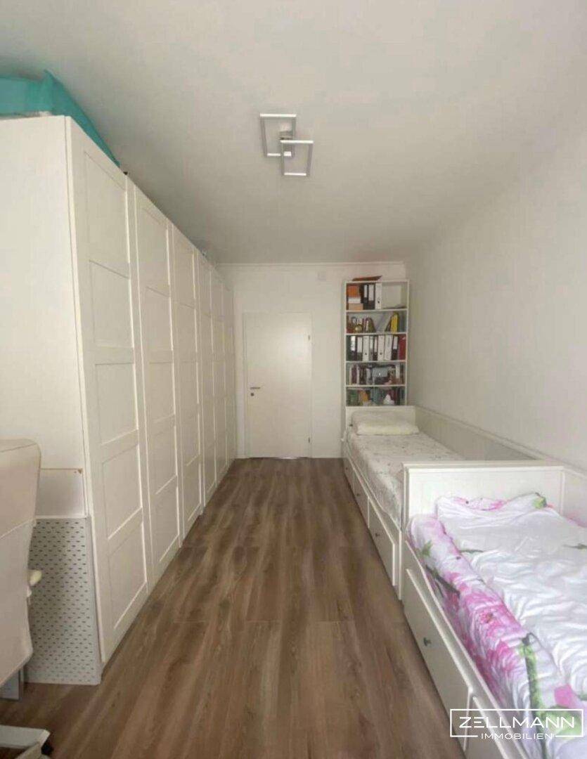 Kinderzimmer oder Gästezimmer mit zwei Einzelbetten und großem Kleiderschrank.