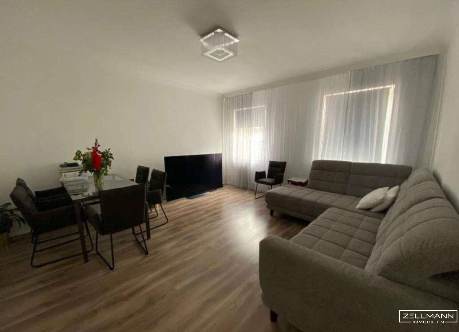 Geräumiger Wohn- und Essbereich mit L-förmigem Sofa und Esstisch.