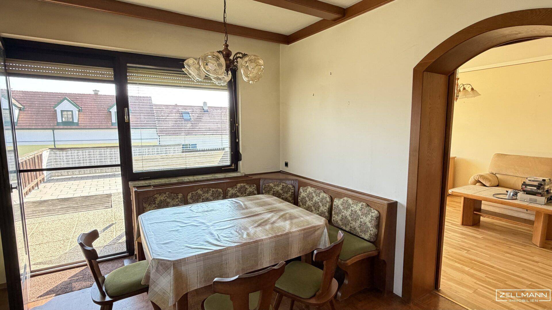 Gemütlicher Essbereich mit Eckbank, Holztisch und Zugang zur Terrasse.