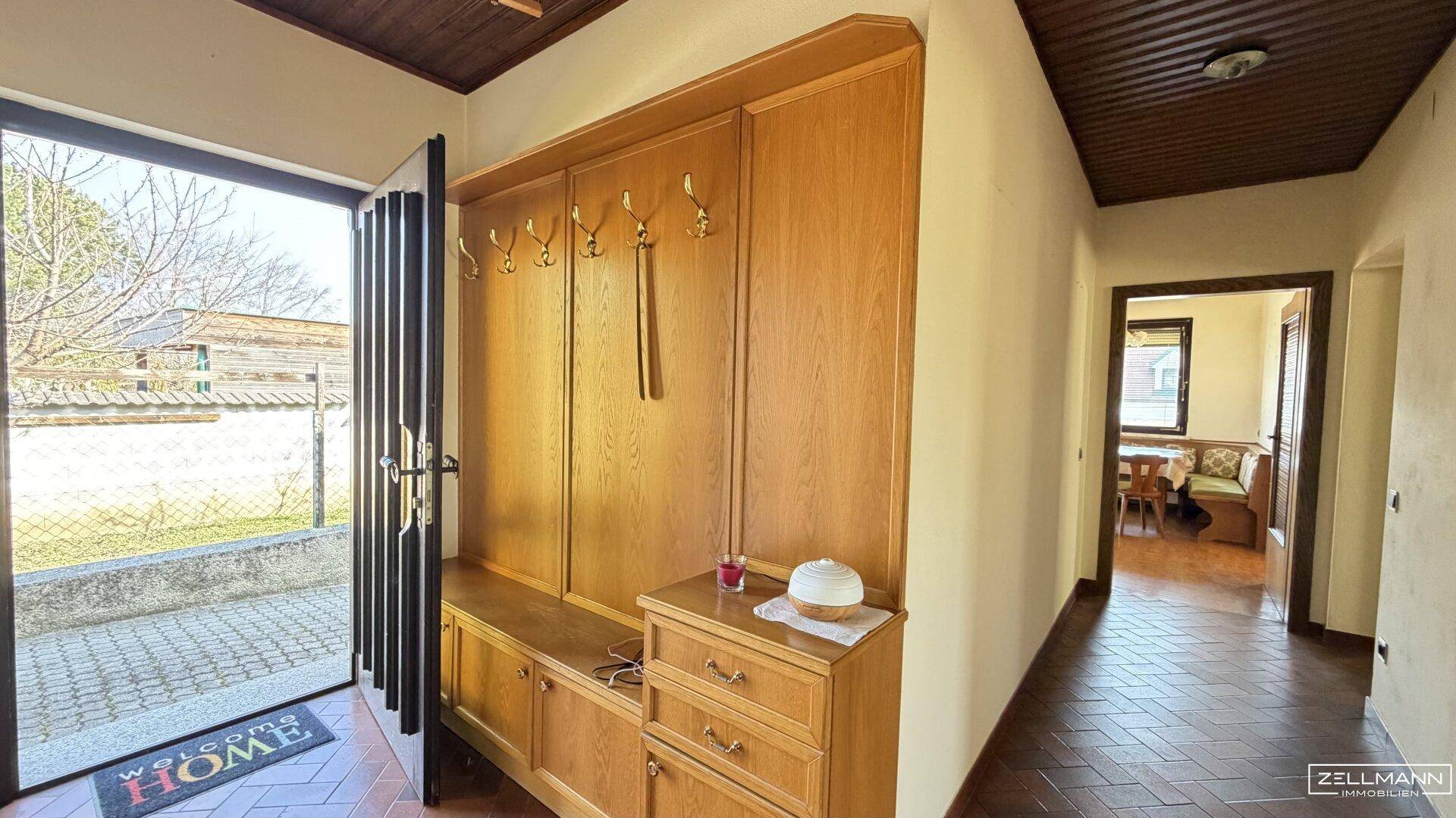 Eingangsbereich mit Garderobe aus Holz und gefliestem Boden.