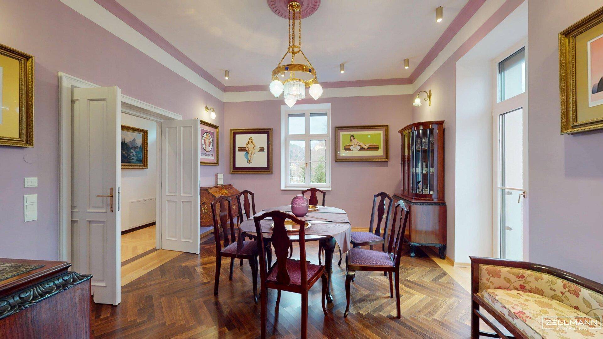 Elegantes Esszimmer mit dunklem Fischgrätparkett, lila Wänden und klassischem Mobiliar.
