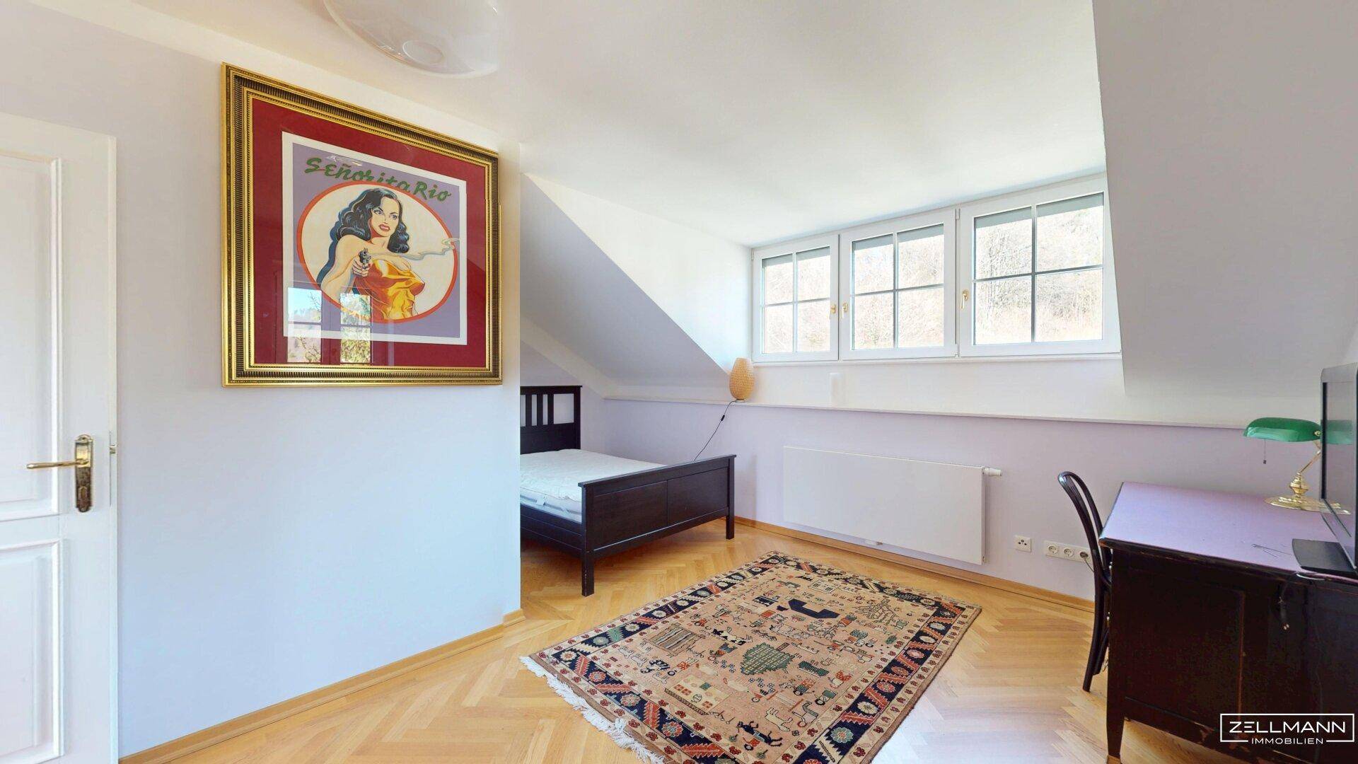 Helles Schlafzimmer im Dachgeschoss mit Schrägen, Parkettboden und Fenster.