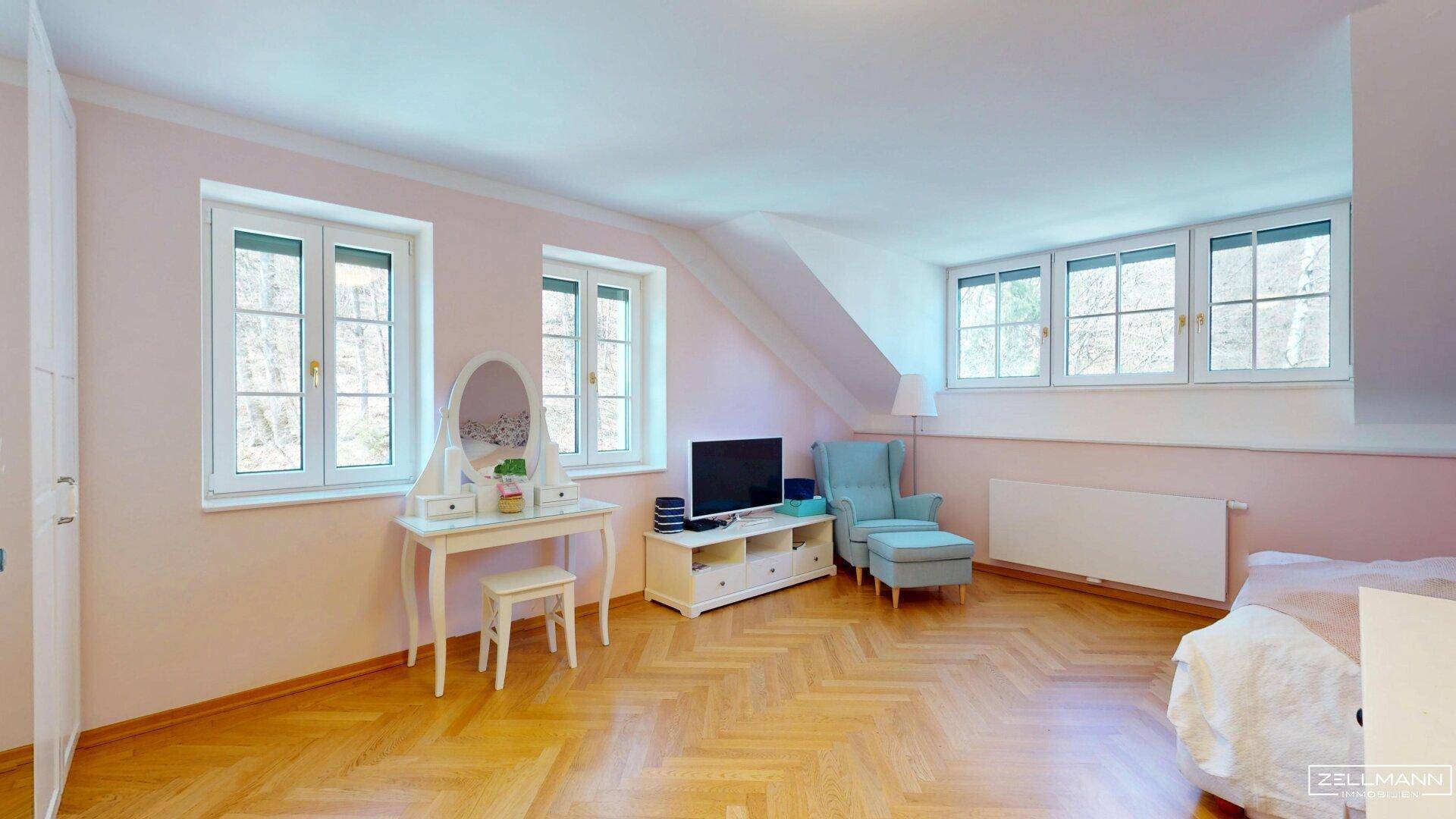 Helles Schlafzimmer im Dachgeschoss mit Schrägen, Parkettboden und Schminktisch.