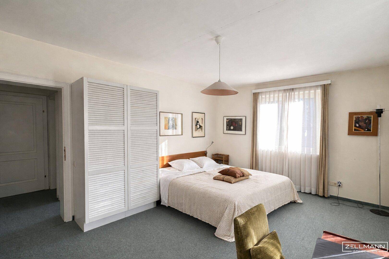 Schlafzimmer mit Teppichboden, Doppelbett und einem praktischen Kleiderschrank.