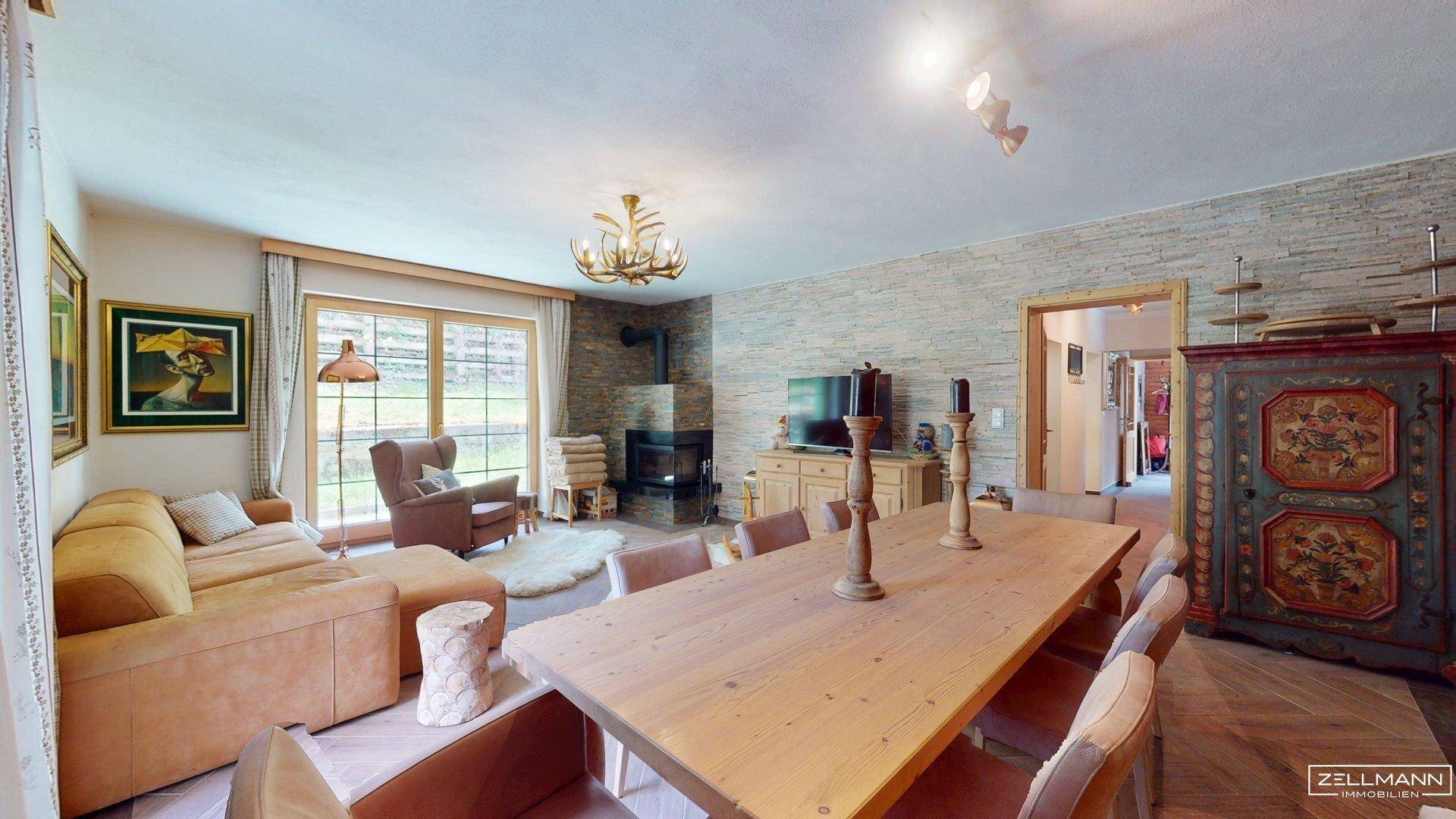 Geräumiger Wohn- und Essbereich mit rustikalem Holztisch, Kamin und traditionellen Möbeln.