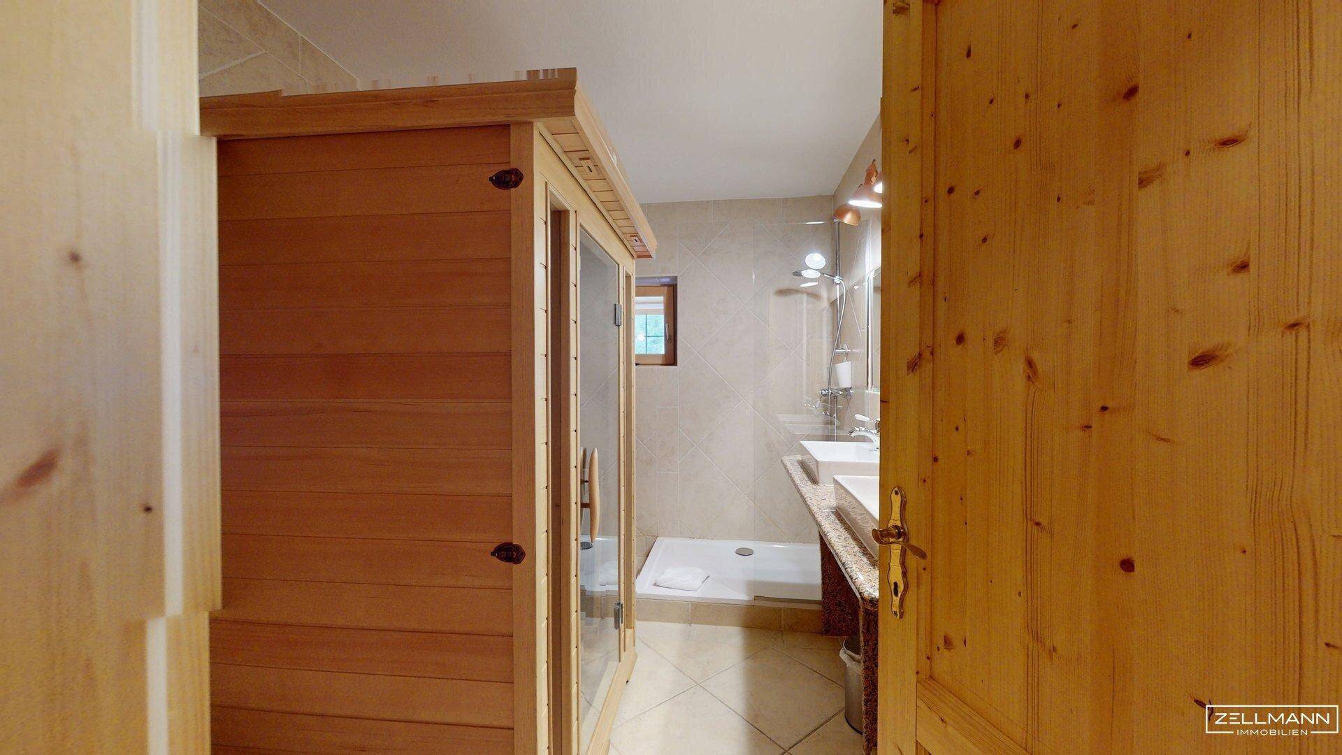 Modernes Badezimmer mit Sauna, Dusche und Doppelwaschbecken, hell gefliest.