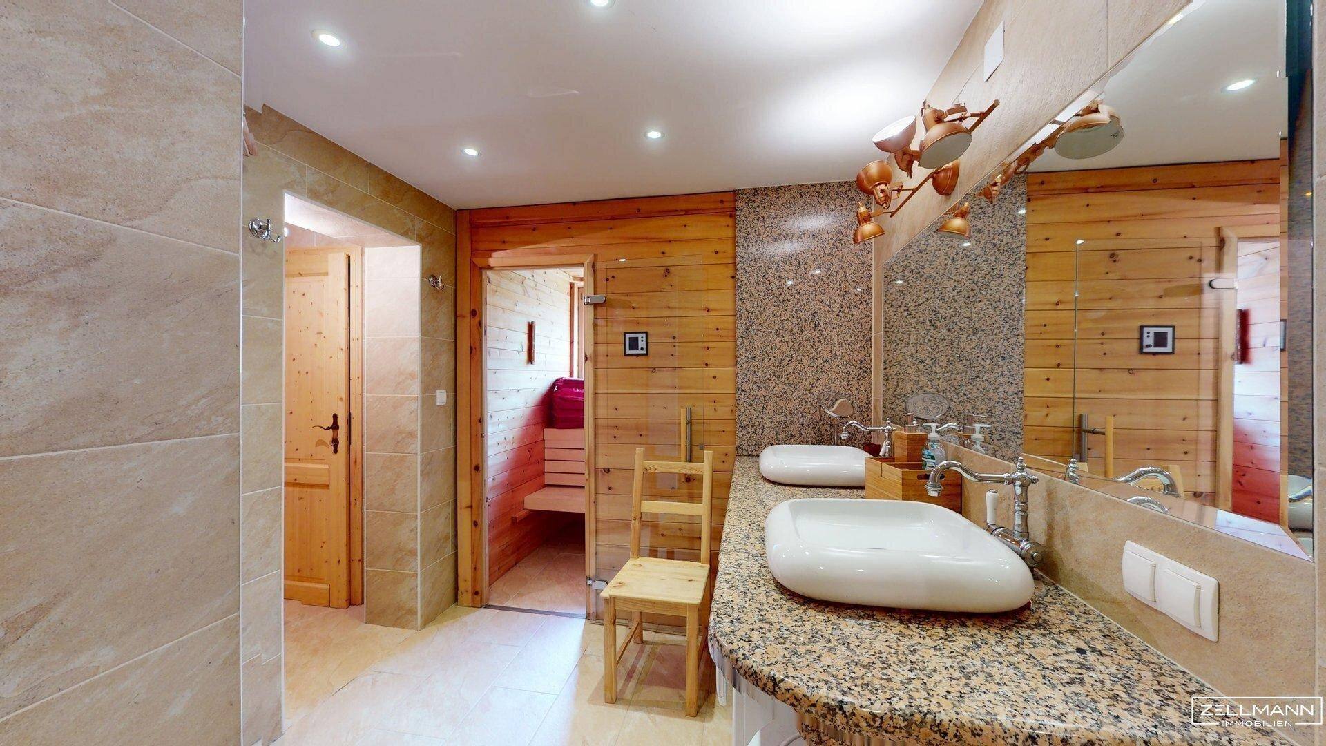 Modernes Badezimmer mit Doppelwaschbecken, Granit-Arbeitsplatte und Zugang zur Sauna.