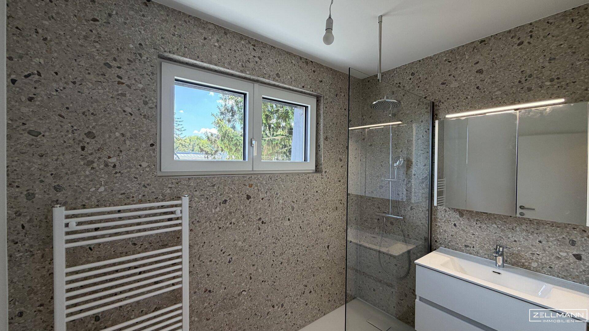 Modernes Badezimmer mit begehbarer Dusche, Fenster und beheiztem Handtuchhalter.