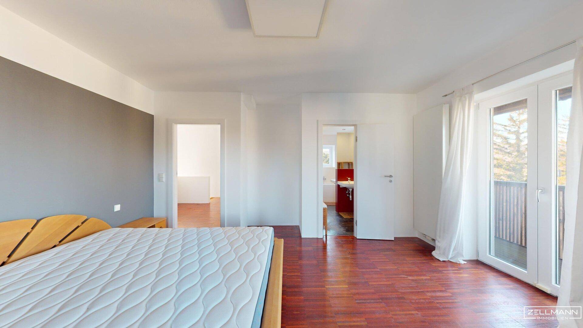 Helles Schlafzimmer mit Holzboden und direktem Zugang zu einem angrenzenden Badezimmer.