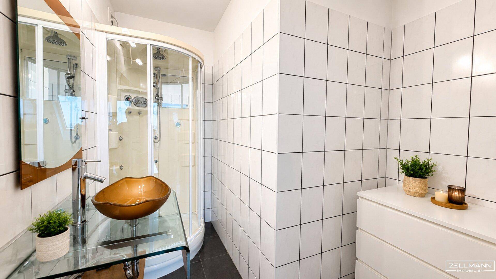 Modernes Badezimmer mit begehbarer Dusche, stilvollem Waschbecken und weißen Fliesen.