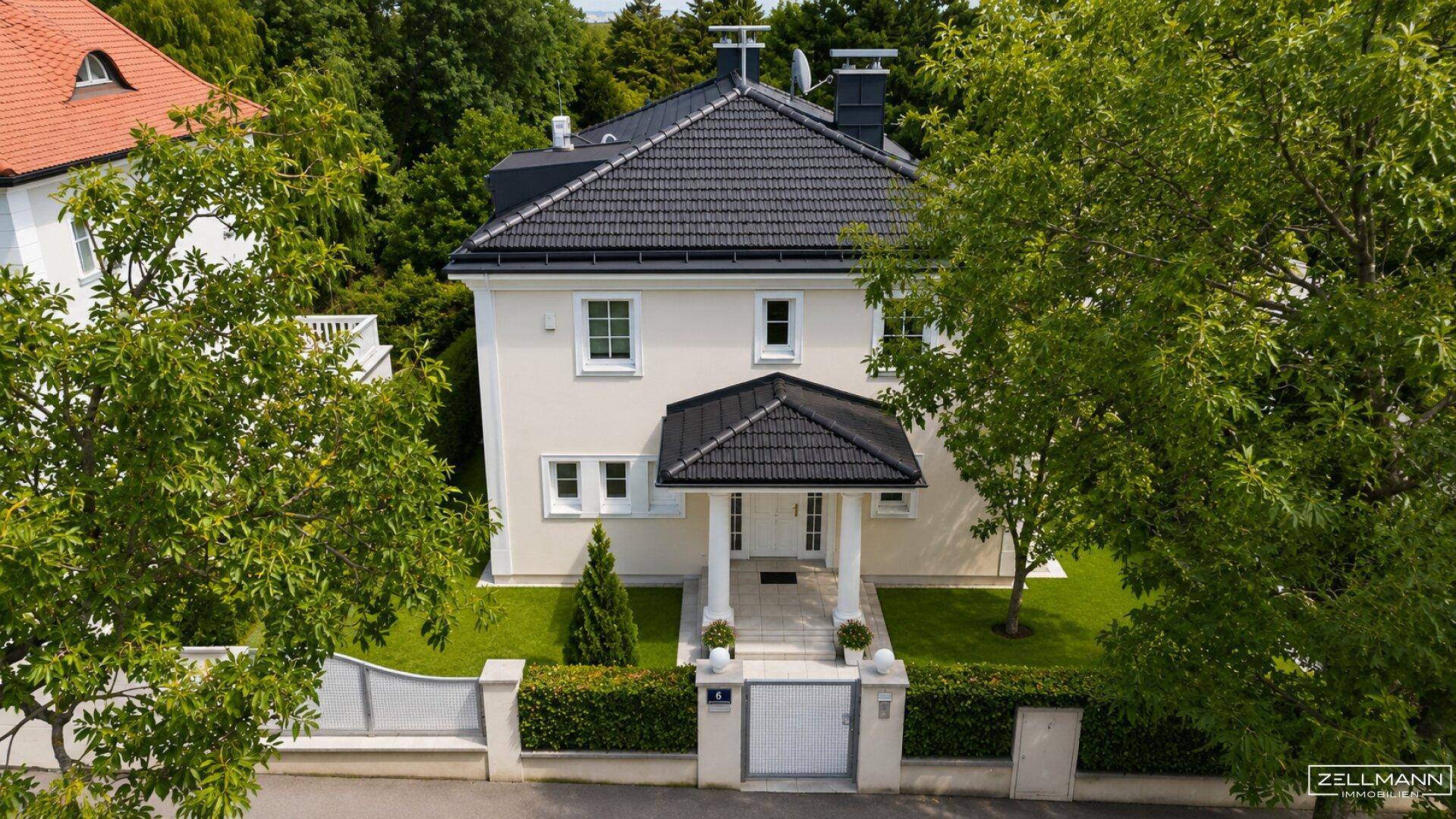 Frontansicht des Hauses aus der Vogelperspektive mit Eingangsbereich und gepflegtem Vorgarten.