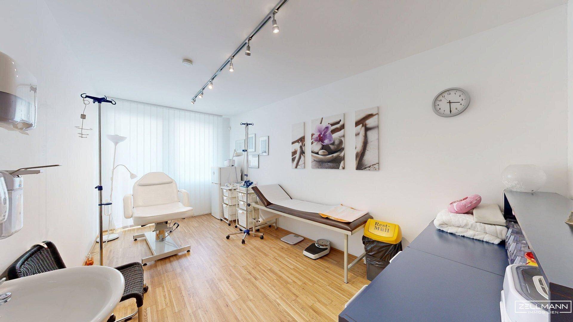 Behandlungszimmer mit Untersuchungsliege, Waschbecken und medizinischen Geräten für den Praxisbetrieb.