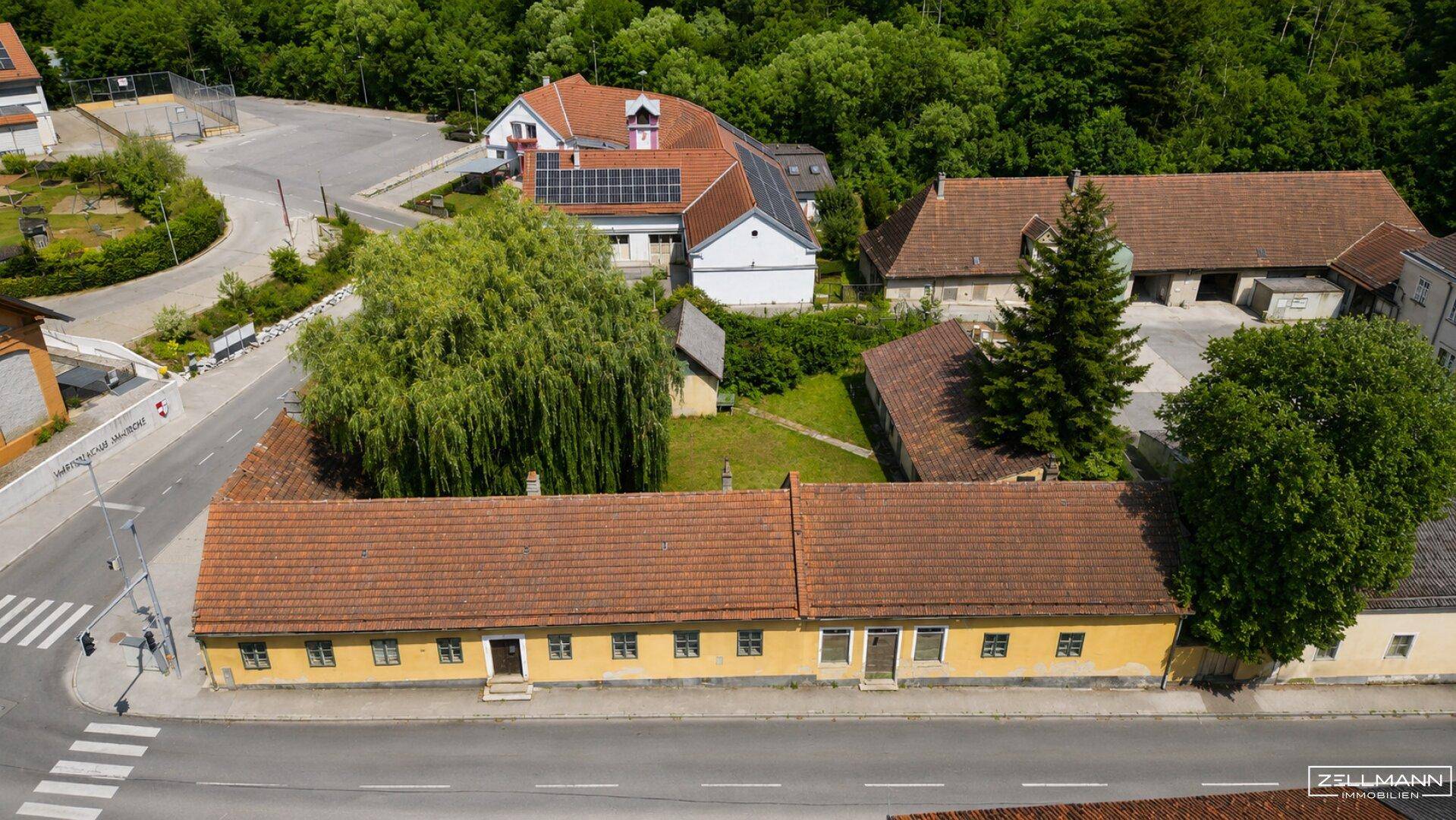 Weitläufige Luftaufnahme des Hauptgebäudes, des Grundstücks und der umliegenden ländlichen Bebauung.