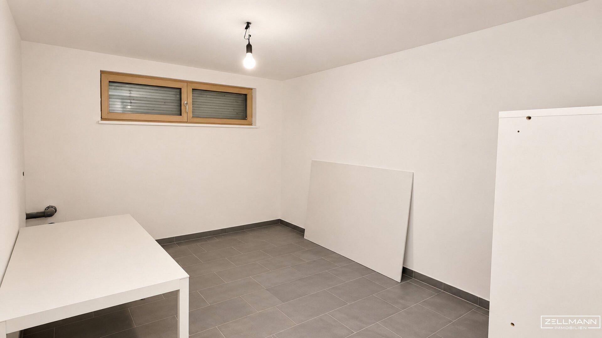 Funktionaler Raum mit Fliesenboden, einem Fenster und einfacher Ausstattung, ideal als Hauswirtschaftsraum.