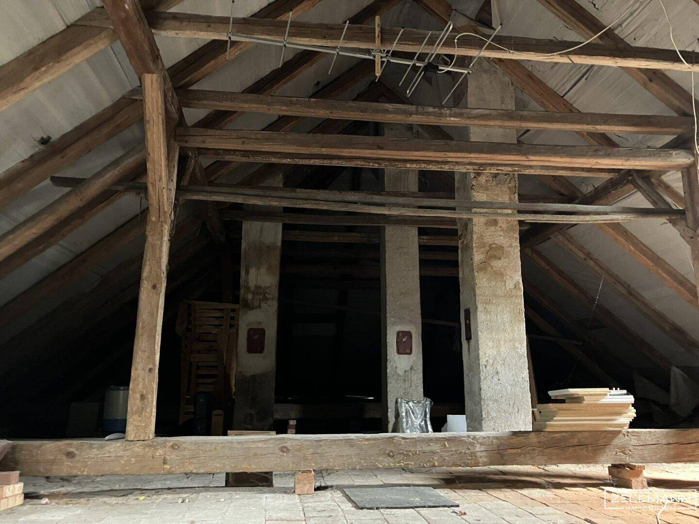 Dachboden mit sichtbaren Holzbalken und Dachkonstruktion, bereit für einen Ausbau.
