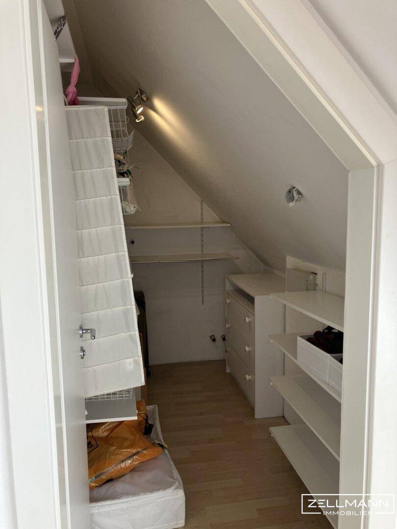 Praktischer Abstellraum im Dachgeschoss mit Regalen und Stauraummöglichkeiten unter der Schräge.