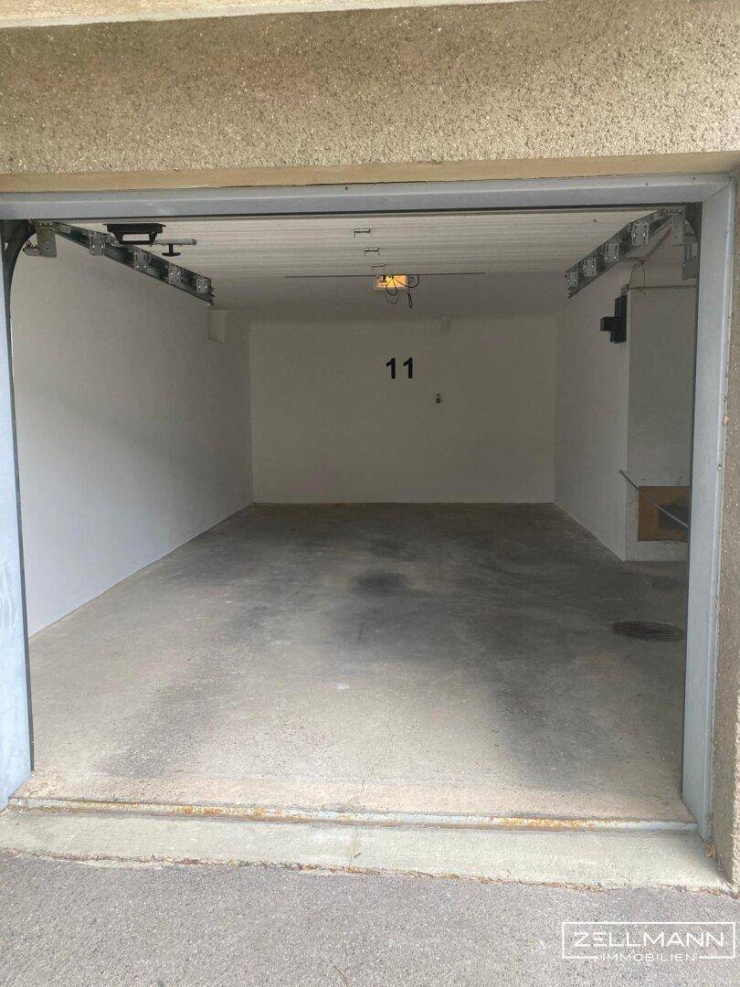 Leere Garage mit Betonboden und der Nummer 11 an der Wand.