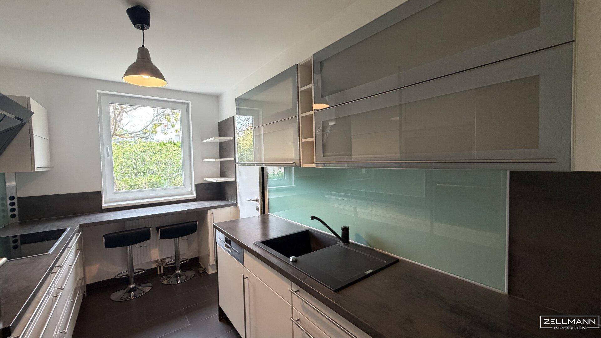 Moderne Küche mit Spülmaschine, Fenster und Bartresen, ideal für schnelle Mahlzeiten.