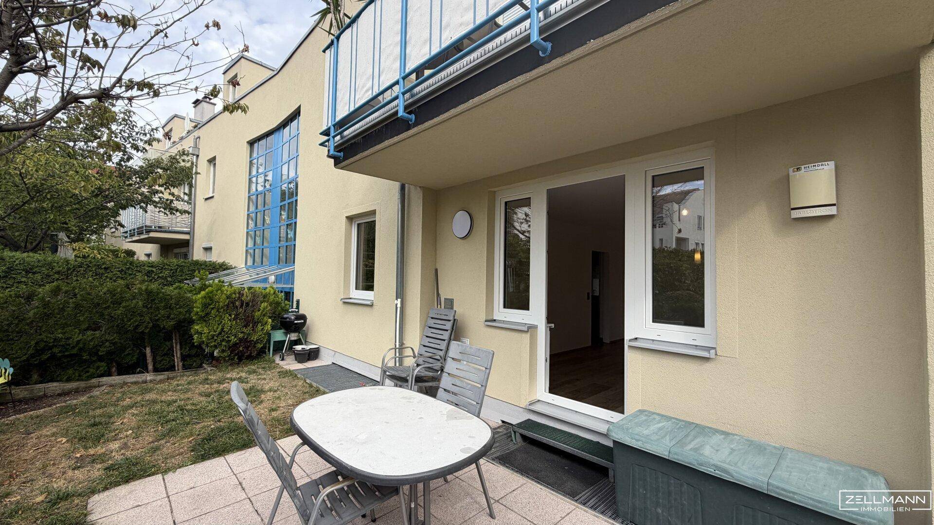 Gemütliche Terrasse mit Gartenmöbeln und Zugang zum Garten, umgeben von Grün.