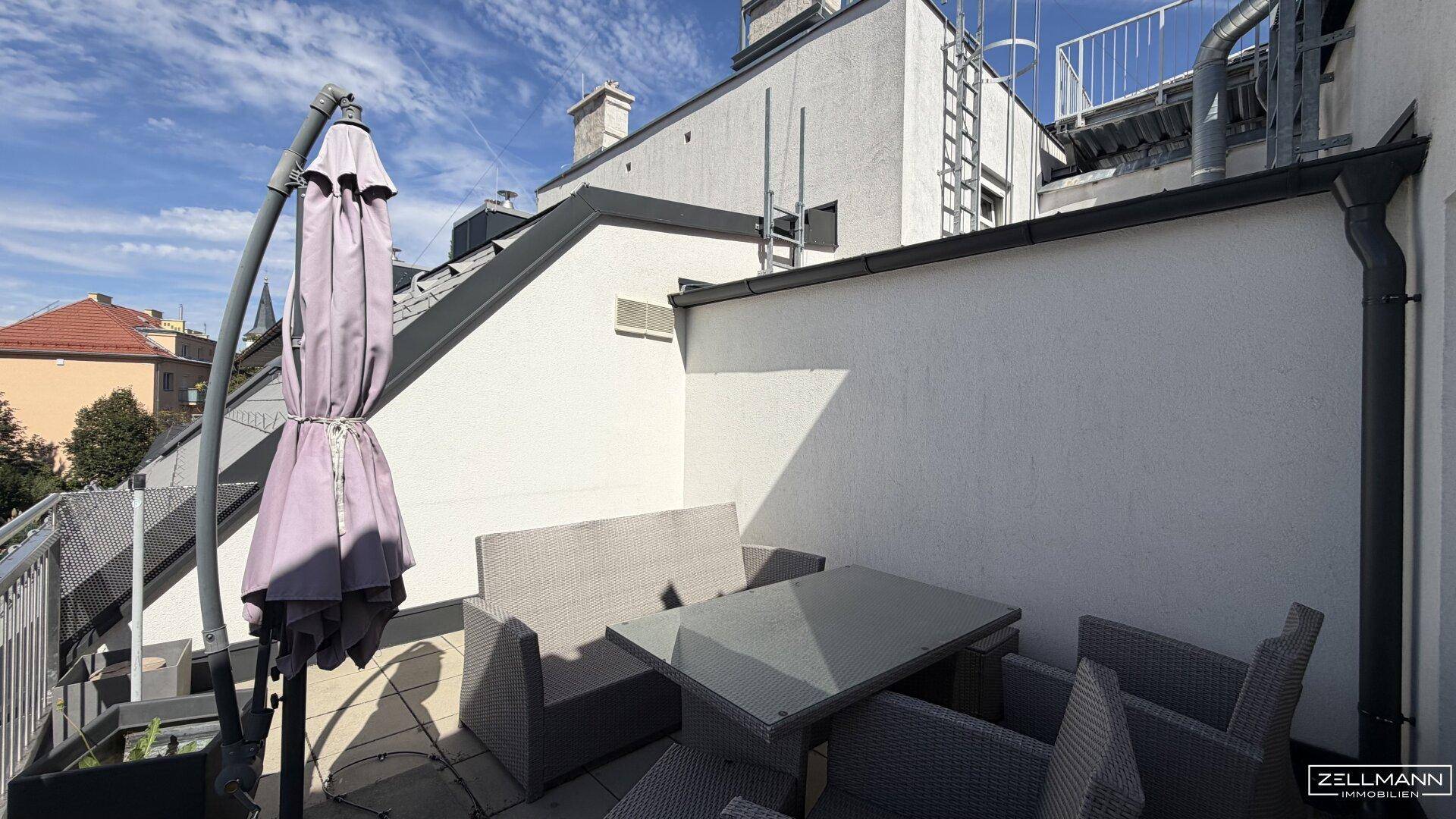 Gemütliche Dachterrasse mit modernen Sitzgelegenheiten und Sonnenschirm für entspannte Stunden.