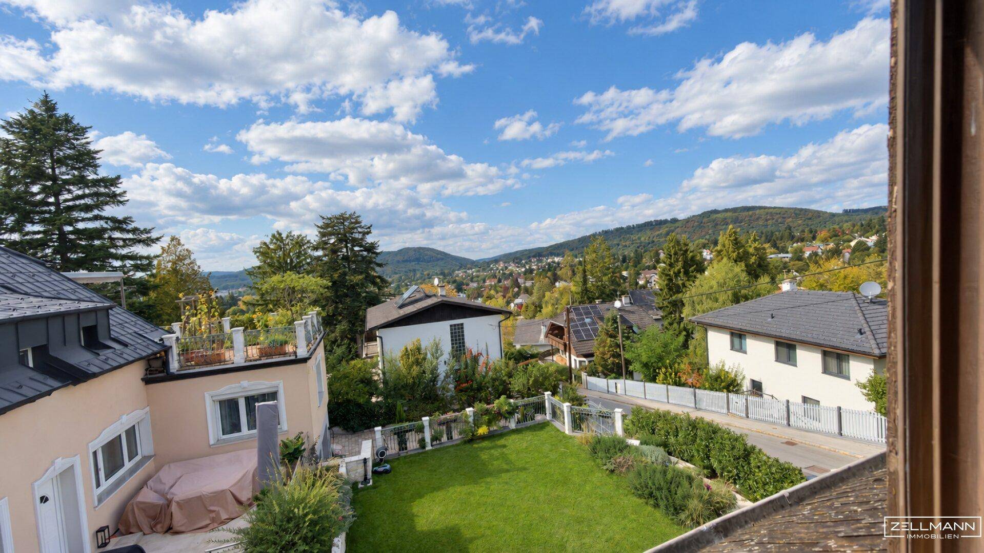 Gepflegter Gartenbereich mit Rasenfläche und weitem Blick auf die umliegende Hügellandschaft.