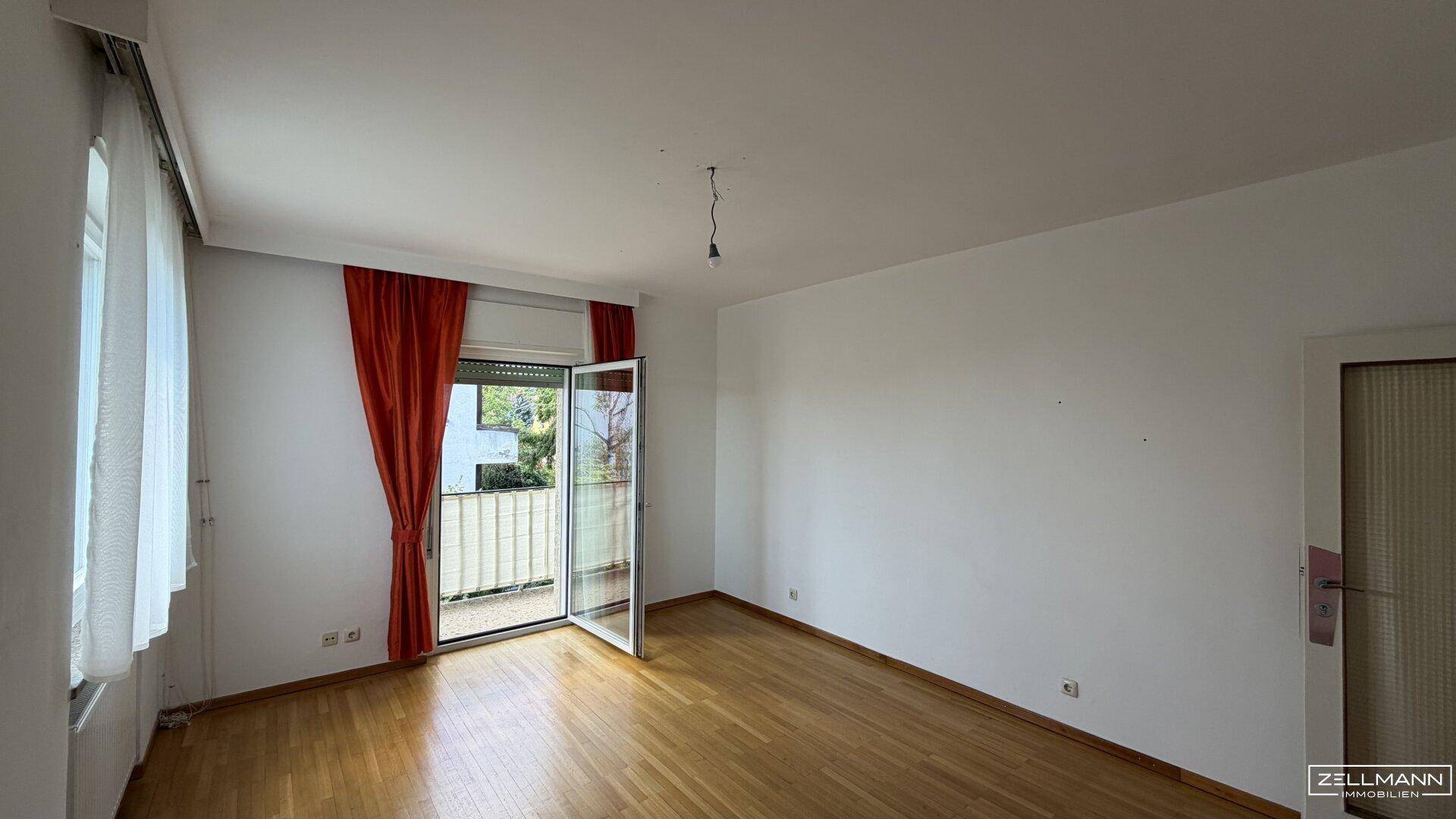 Geräumiges Zimmer mit Parkettboden und Balkonzugang, bereit für individuelle Gestaltung.
