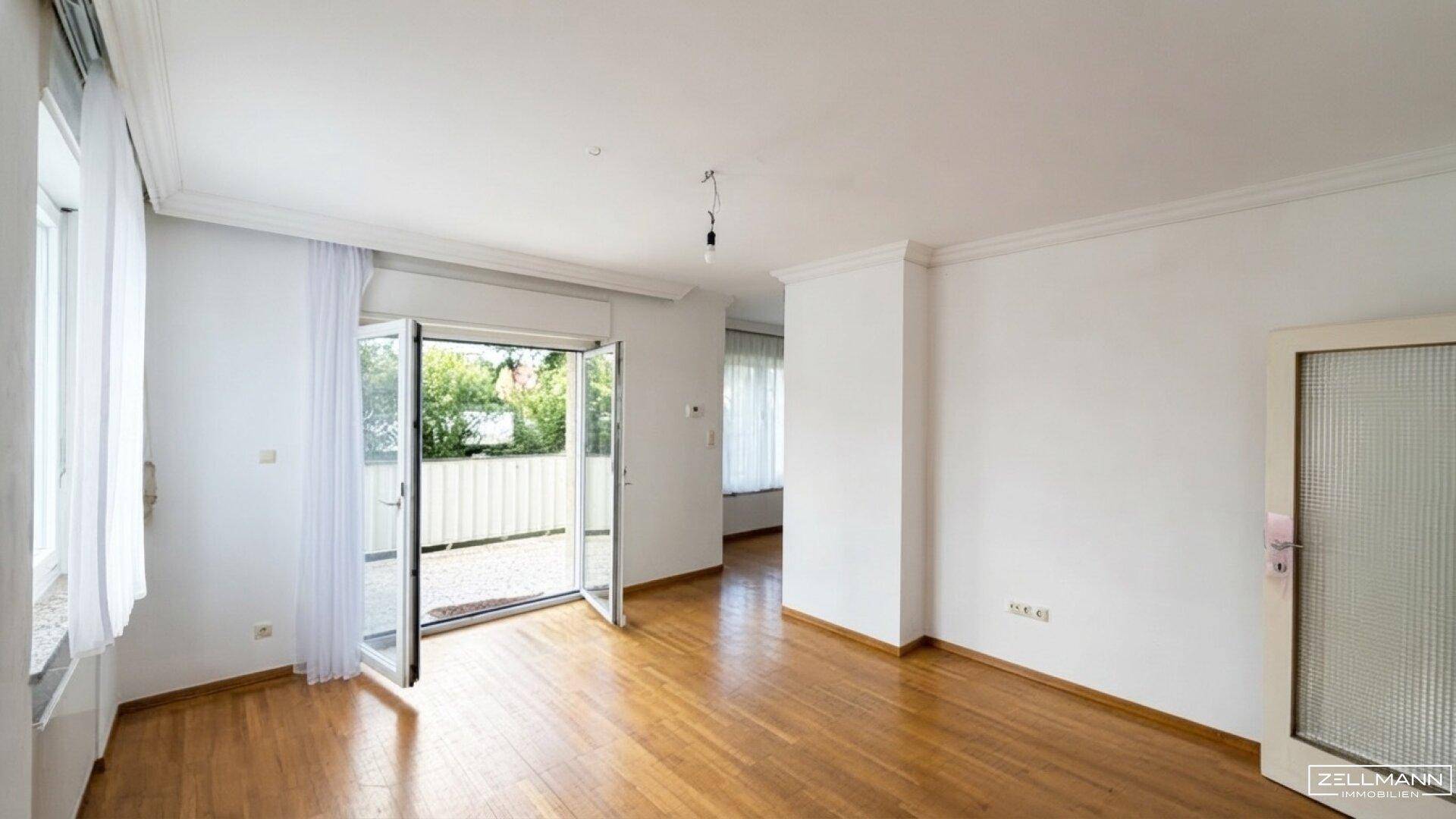 Geräumiges, helles Zimmer mit Holzboden und direktem Zugang zu einer Terrasse oder Garten.