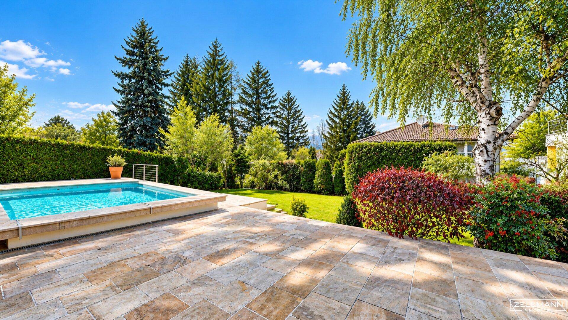 Außenbereich mit Swimmingpool, großzügiger Steinterrasse und umgebender Hecke.