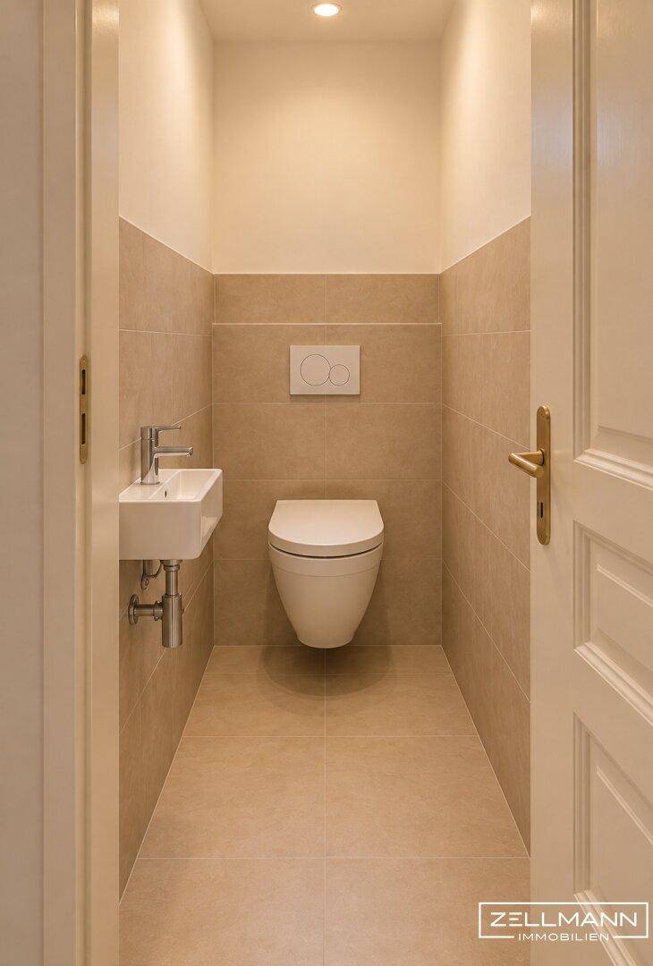 Kleines Gäste-WC mit beigefarbenen Fliesen, wandhängendem WC und kleinem Waschbecken.