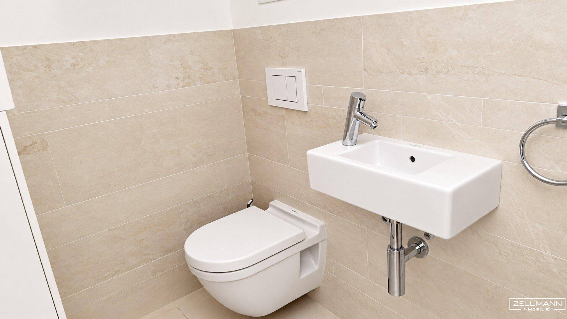 Kompaktes Gäste-WC mit wandhängender Toilette und kleinem Waschbecken.