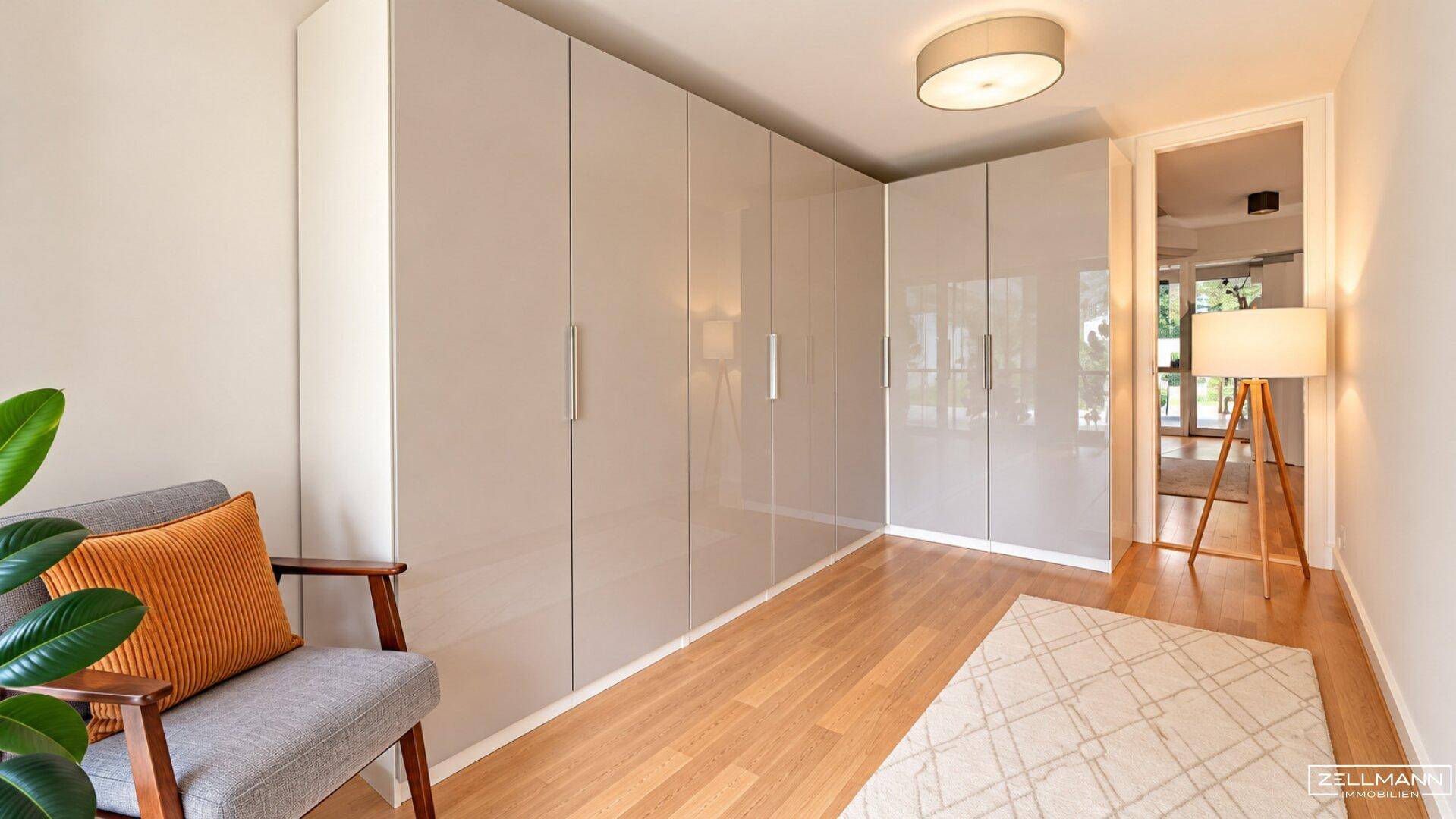 Schlafzimmer mit Einbauschränken, Holzboden und gemütlichem Sessel.