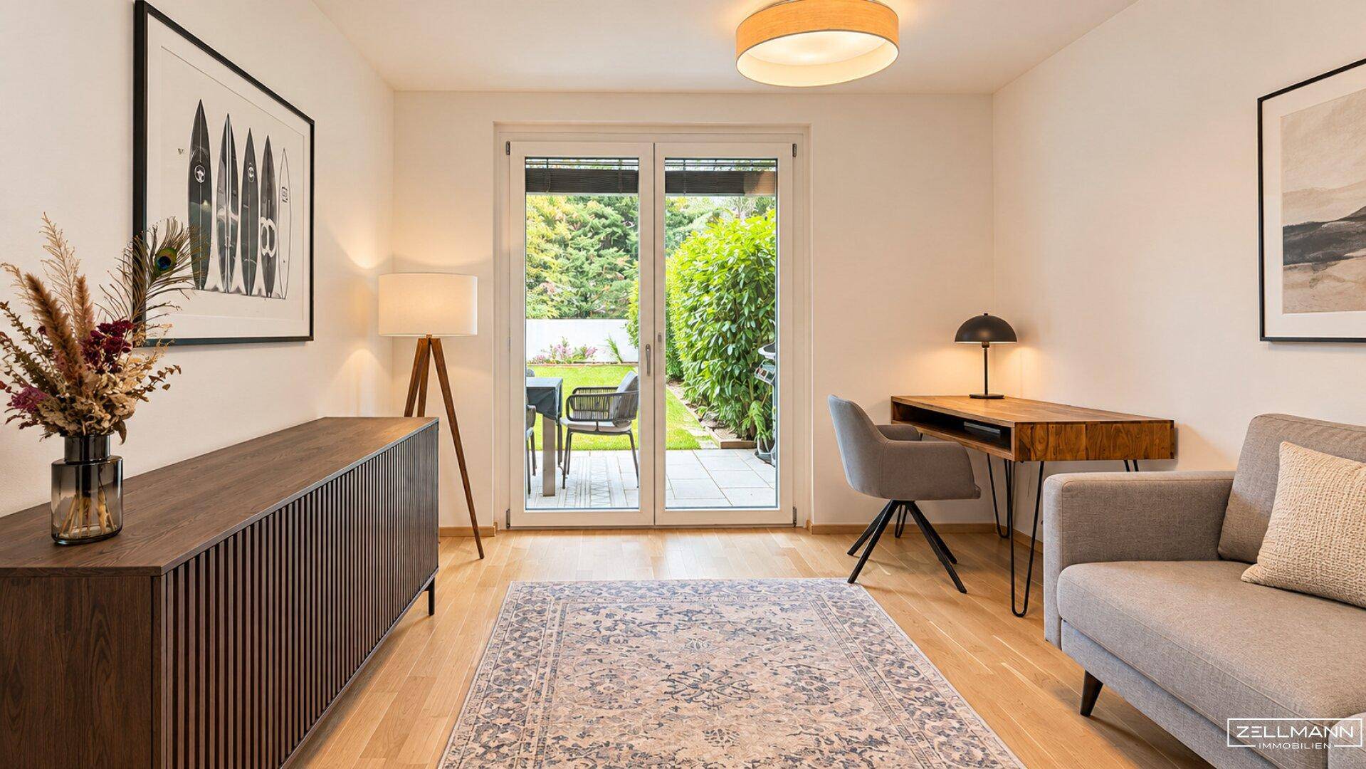 Helles Arbeitszimmer mit Holzboden, modernem Schreibtisch und Zugang zum Garten.