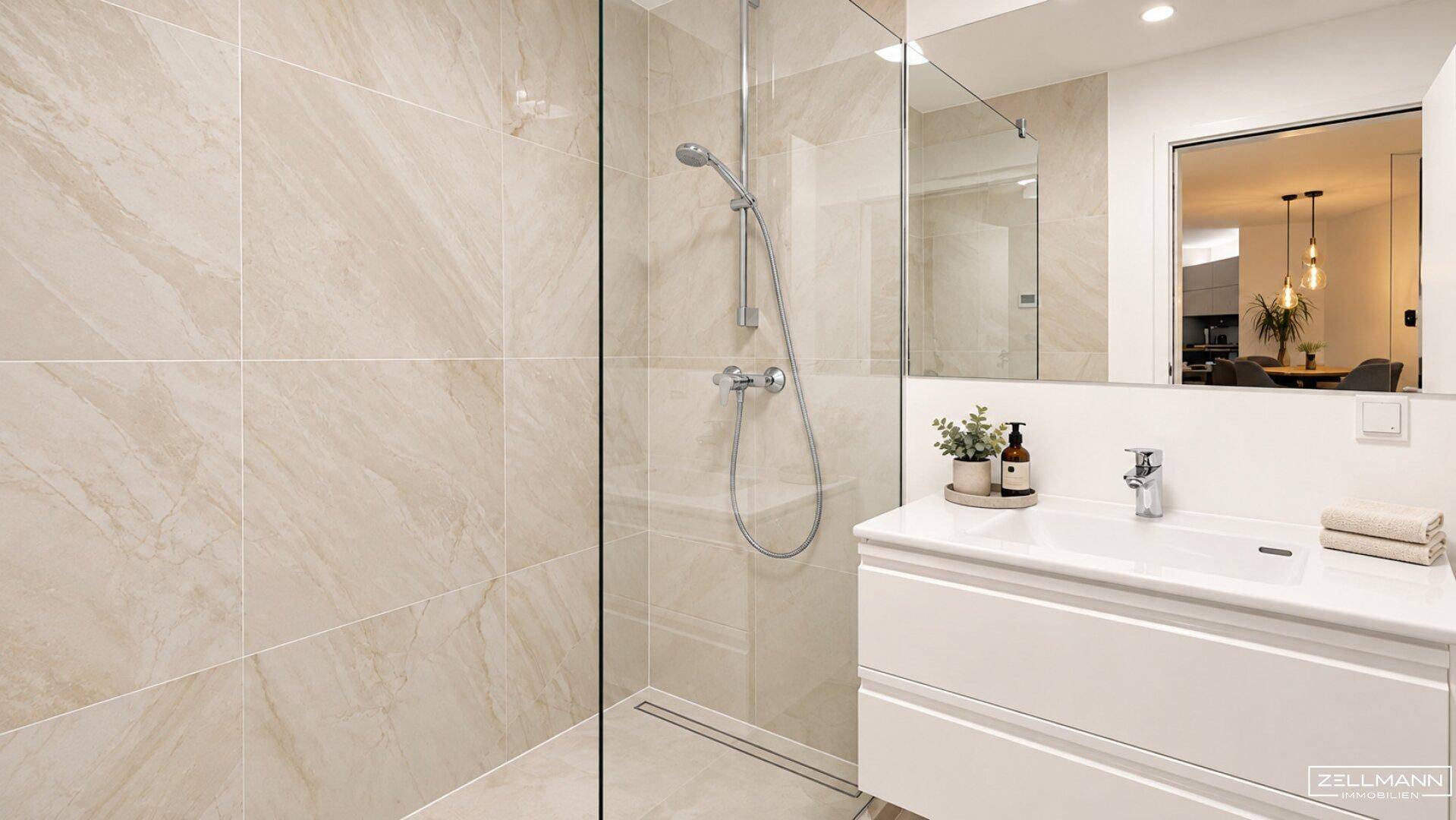 Modernes Badezimmer mit bodengleicher Dusche, Waschtisch und hellen Fliesen.