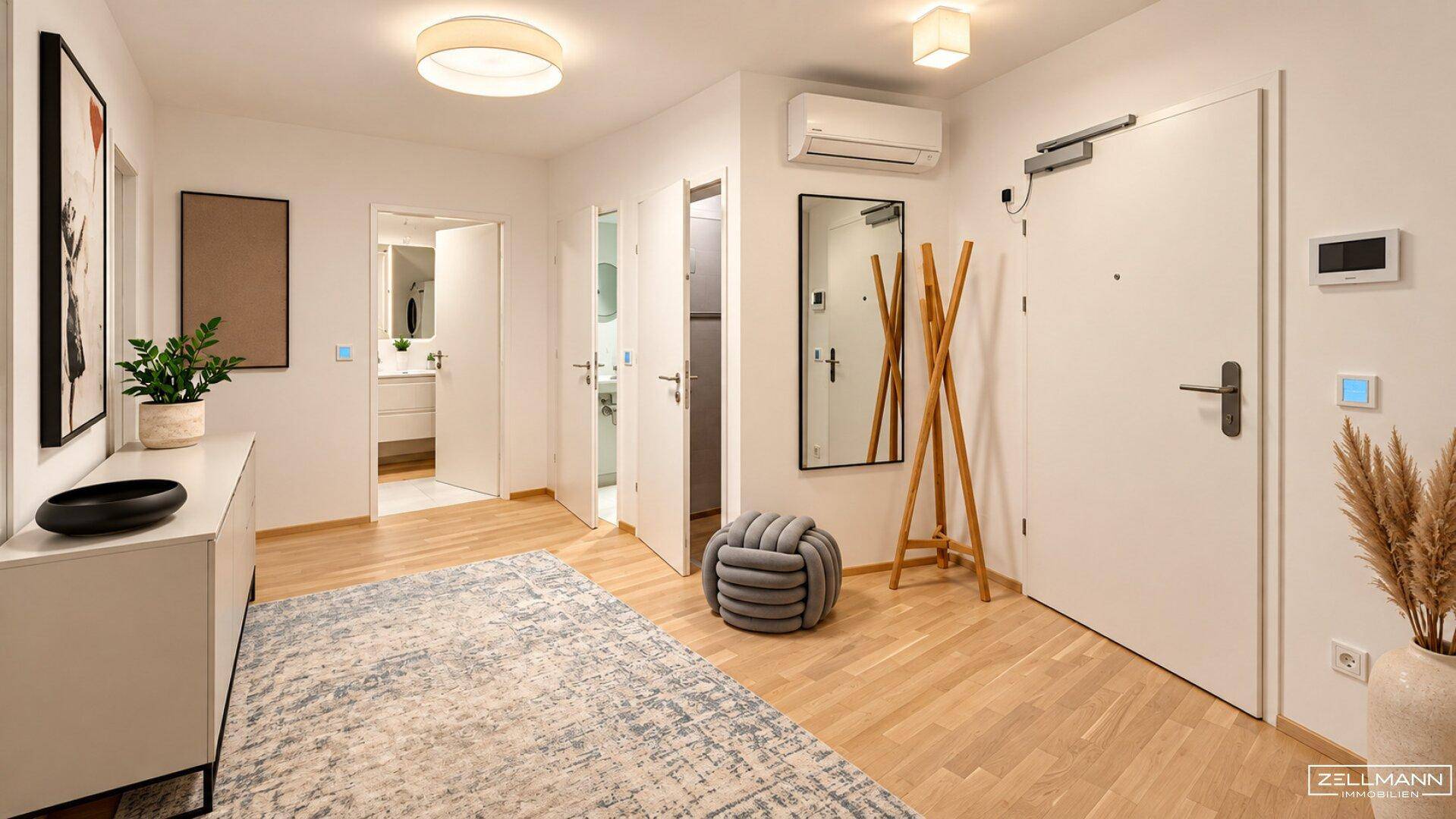 Heller Eingangsbereich mit Holzboden, Spiegel und Garderobe.