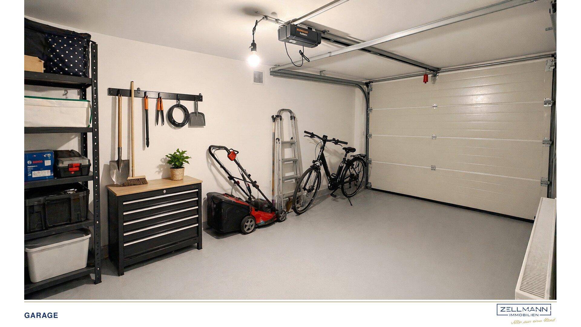 Geräumige Garage mit automatischem Tor, Stauraum und Platz für Fahrräder und Gartengeräte.