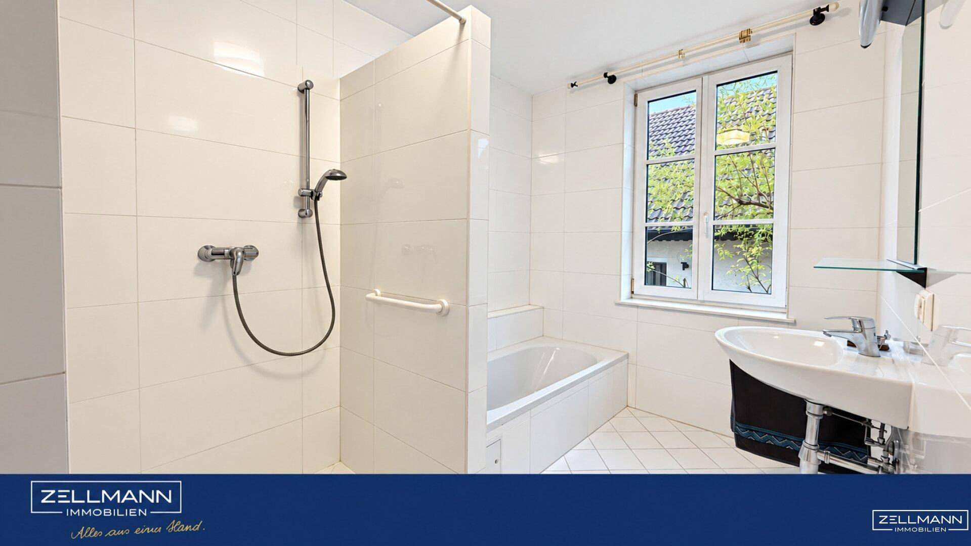 Helles Badezimmer mit weißen Fliesen, Dusche, Badewanne und Fenster.