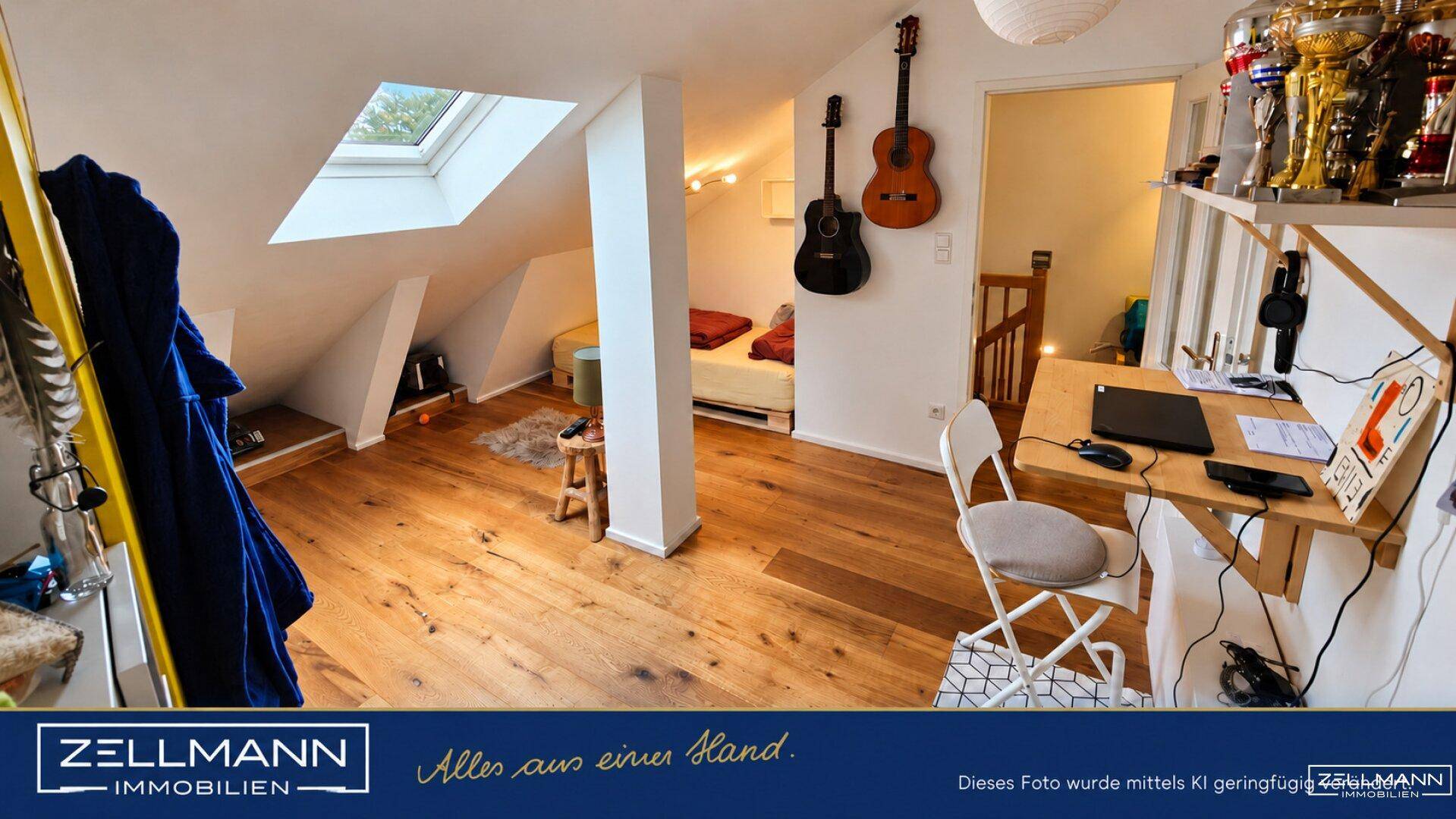 Gemütliches Dachzimmer mit Holzboden, Dachfenster und Platz für Schlaf- und Arbeitsbereich.